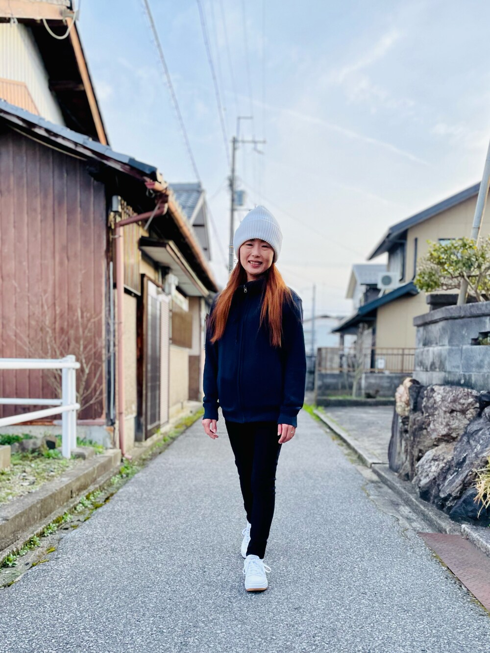 ホワイト系のスニーカー、ブラック系のスウェットパンツ、ブルー系のパーカーを着用したレディースの春コーディネートの4枚目の写真