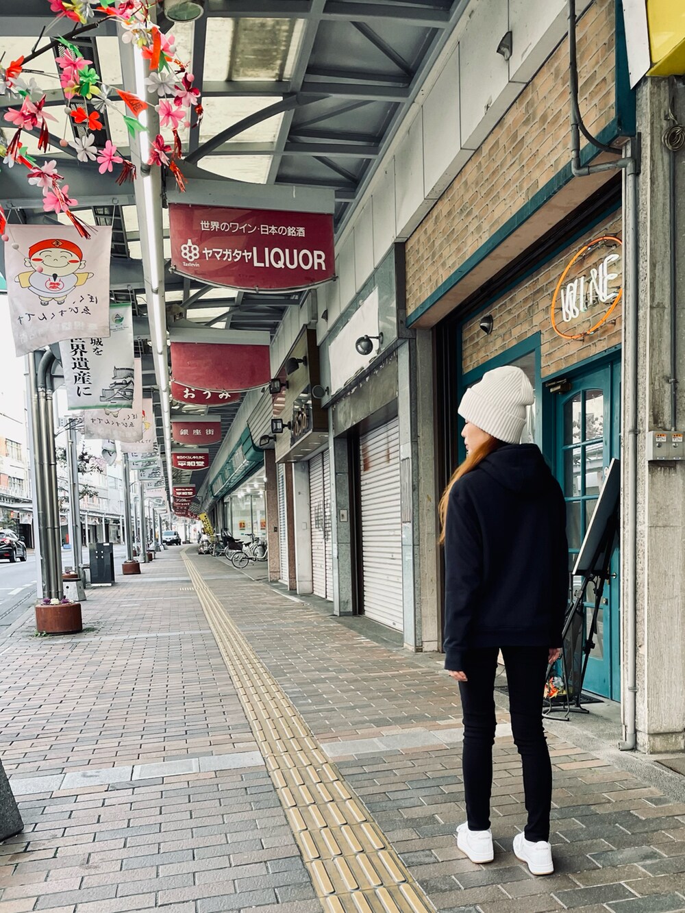 ホワイト系のスニーカー、ブラック系のスウェットパンツ、ブルー系のパーカーを着用したレディースの春コーディネートの2枚目の写真