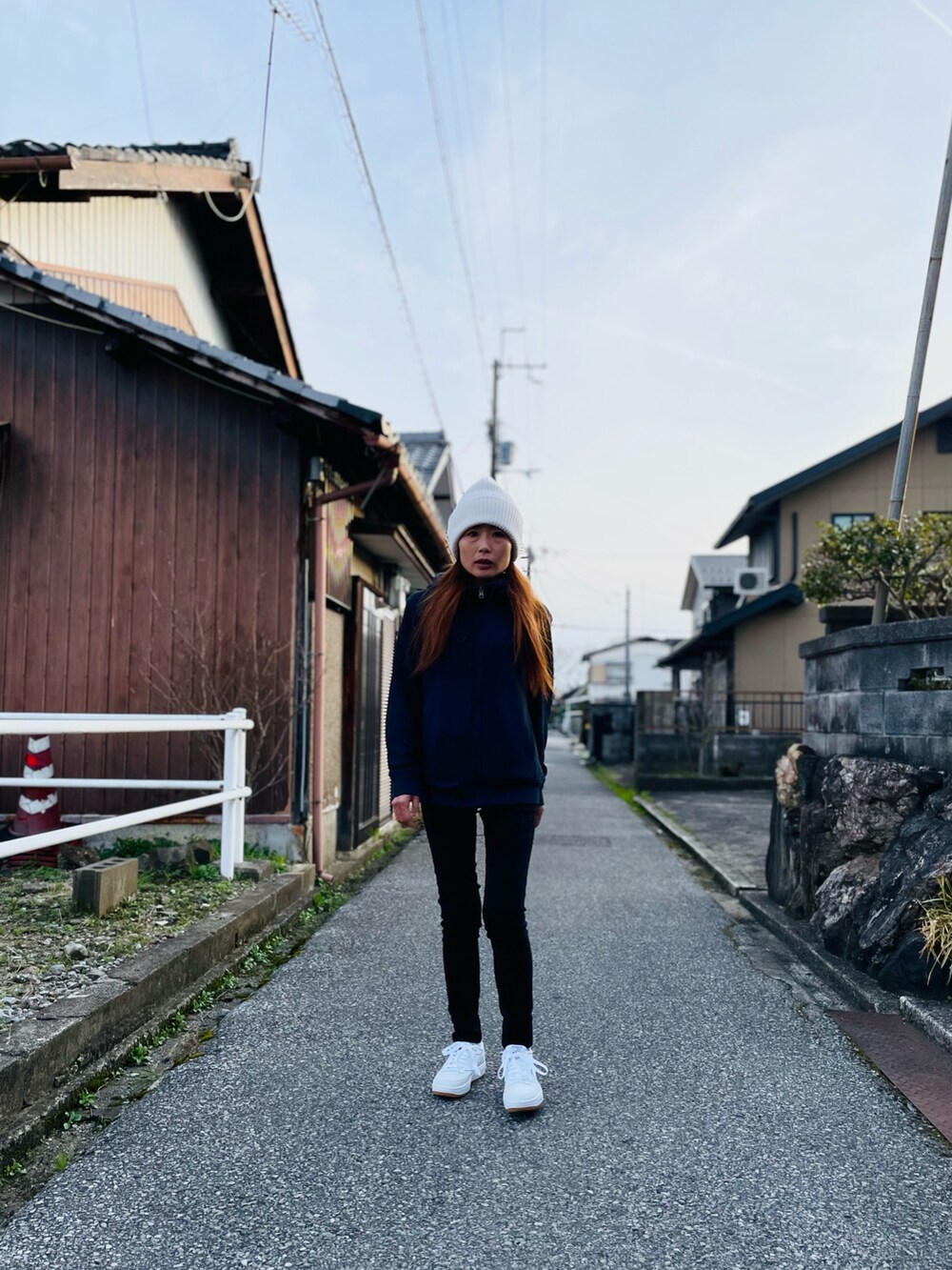 ホワイト系のスニーカー、ブラック系のスウェットパンツ、ブルー系のパーカーを着用したレディースの春コーディネートの3枚目の写真