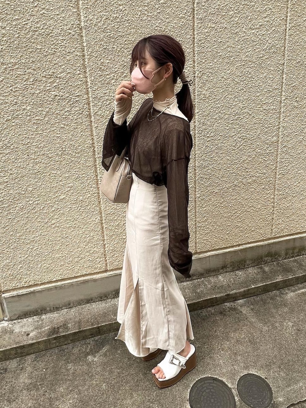 ベージュ系のハンドバッグ、ブラウン系のTシャツ/カットソー、ホワイト系のTシャツ/カットソーを着用したレディースの秋コーディネートの2枚目の写真