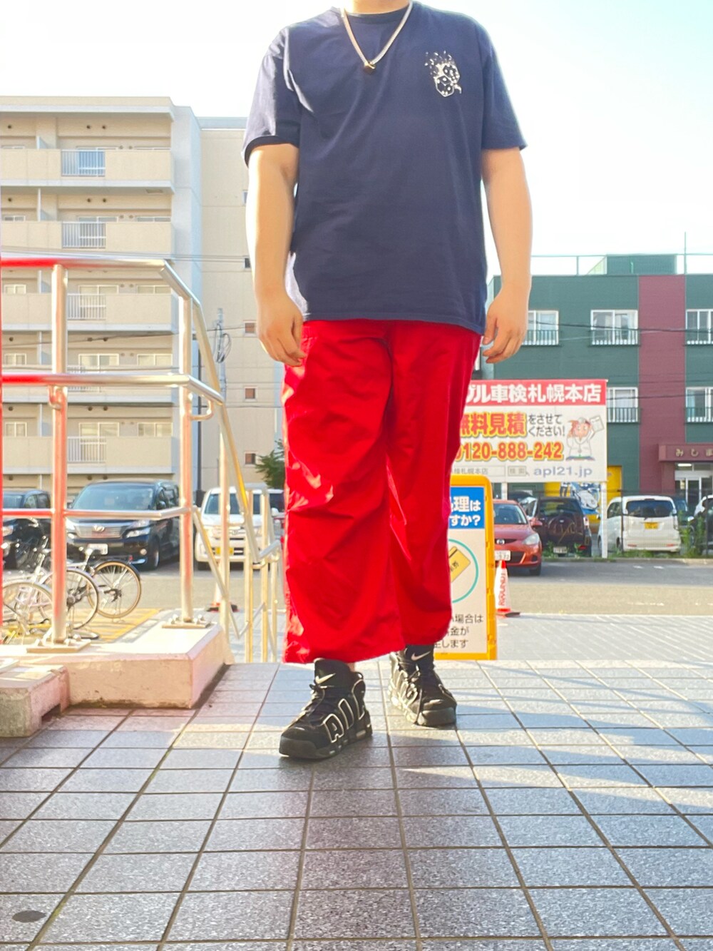ブルー系のTシャツ/カットソー、レッド系のパンツ、ブラック系のスニーカーを着用したメンズの夏コーディネートの2枚目の写真