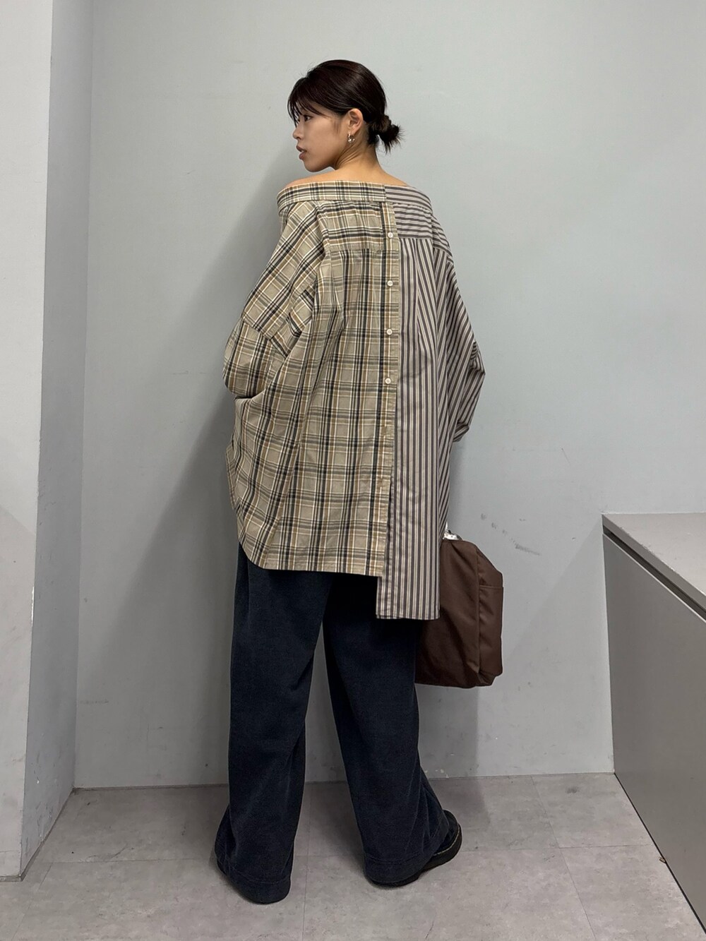 ブラウン系のスカート、ブラック系のスウェットパンツ、ブラウン系のショルダーバッグを着用したレディースの春コーディネートの2枚目の写真