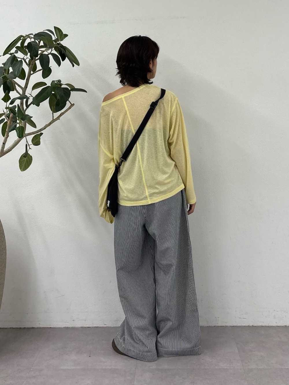 ブルー系のデニムパンツ、イエロー系のTシャツ/カットソー、ブラック系のショルダーバッグを着用したレディースの春コーディネートの3枚目の写真