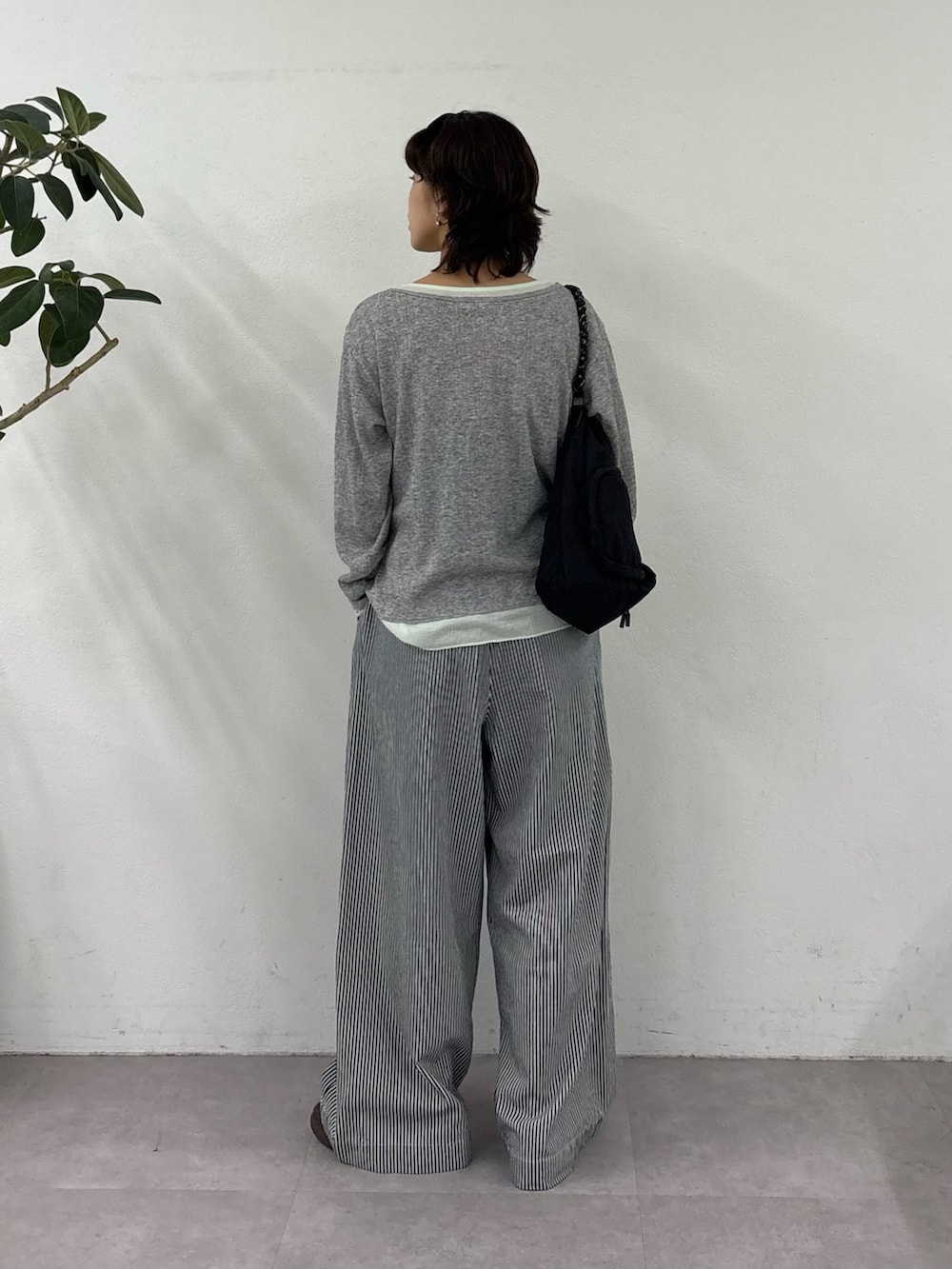 グレー系のカーディガン/ボレロ、ブルー系のデニムパンツ、ブラック系のショルダーバッグを着用したレディースの春コーディネートの3枚目の写真