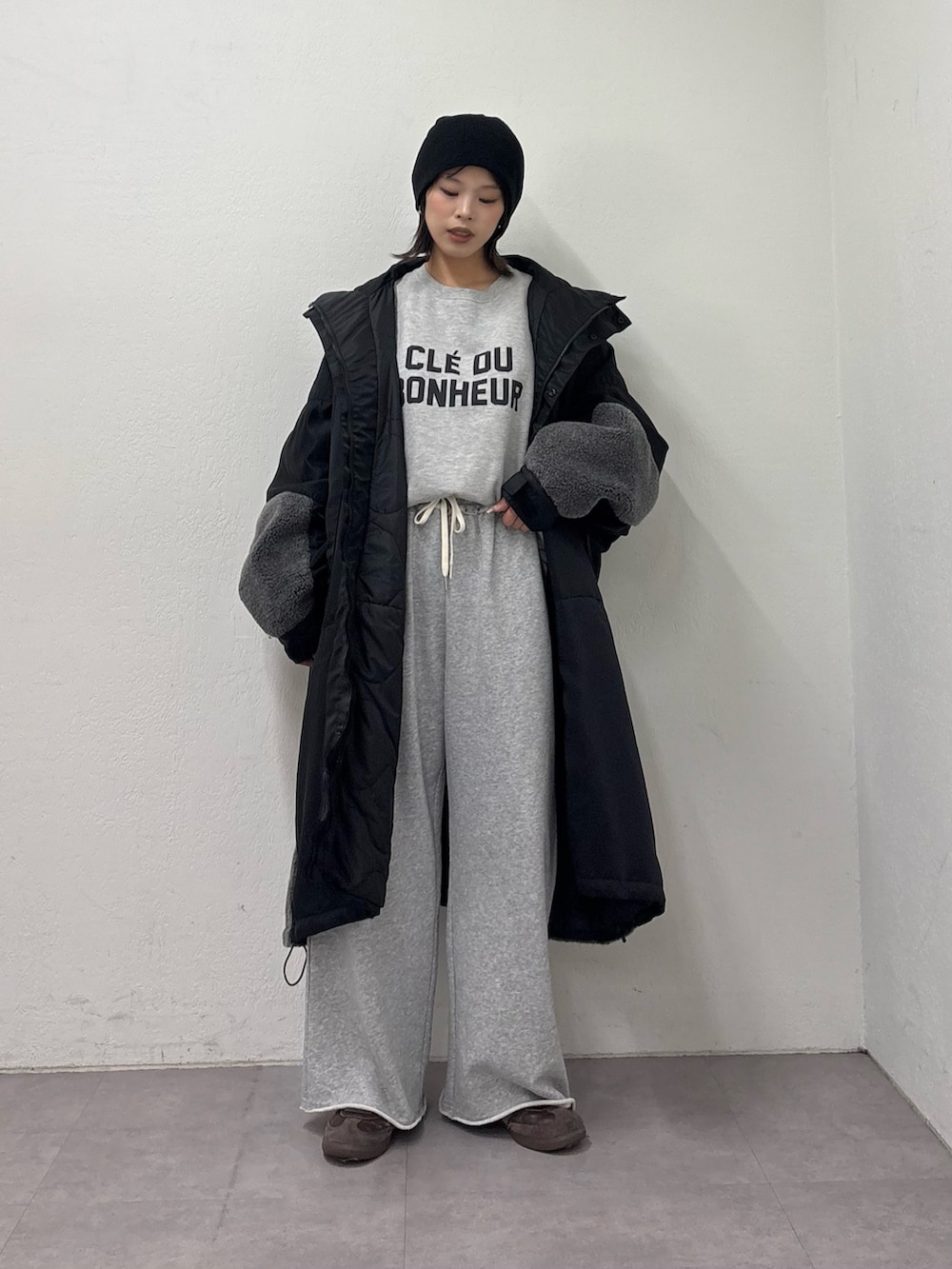 ブラック系のモッズコート、グレー系のスウェットパンツ、グレー系のスウェットを着用したレディースの冬コーディネートの2枚目の写真