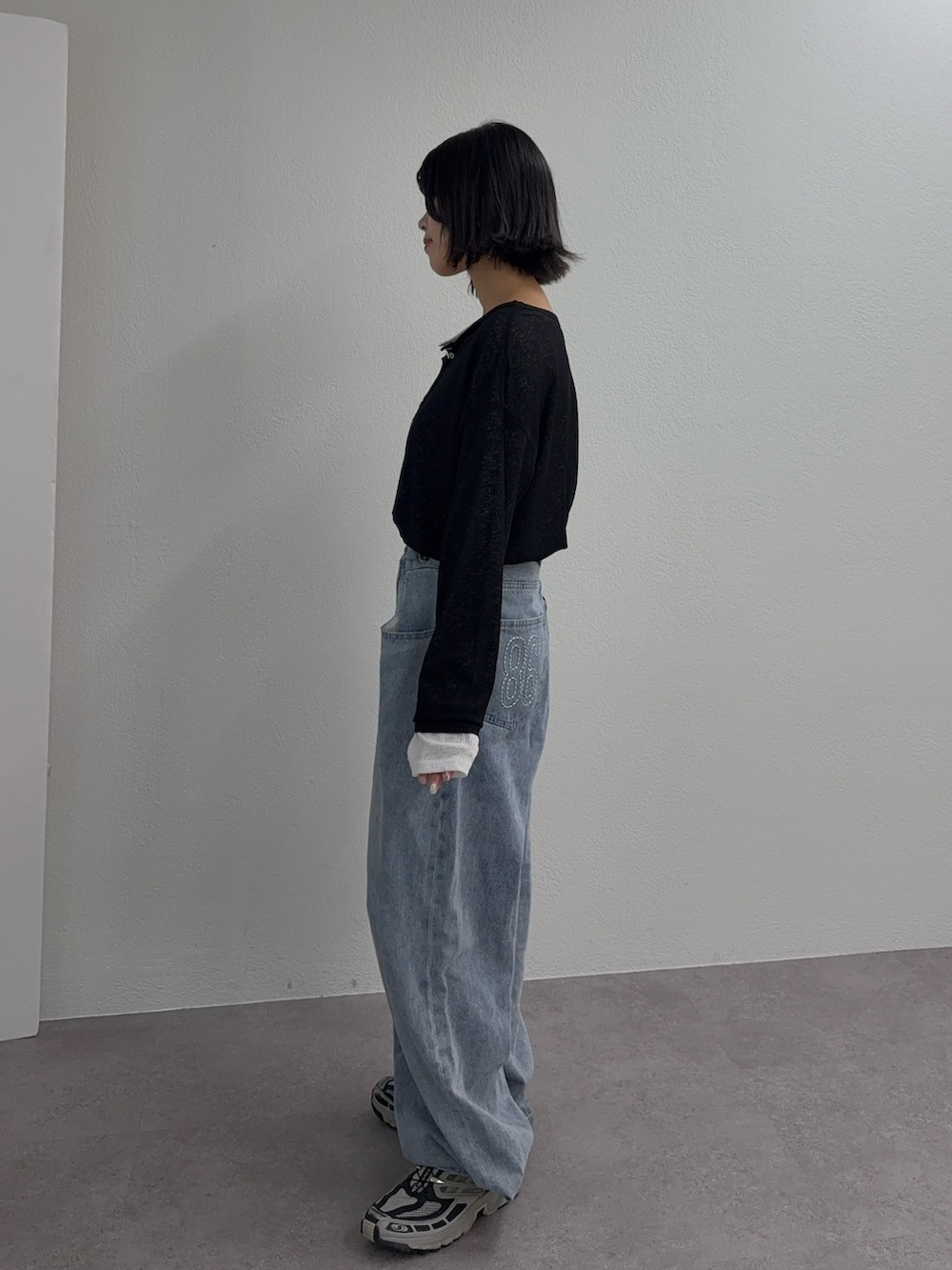 ホワイト系のTシャツ/カットソー、ブラック系のTシャツ/カットソー、ブルー系のデニムパンツを着用したレディースの秋コーディネートの2枚目の写真