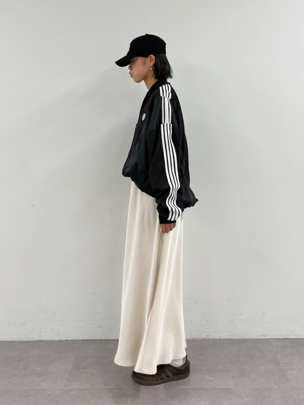 ブラック系のジャージ、ホワイト系のTシャツ/カットソー、ホワイト系のスカートを着用したレディースの秋コーディネートの2枚目の写真