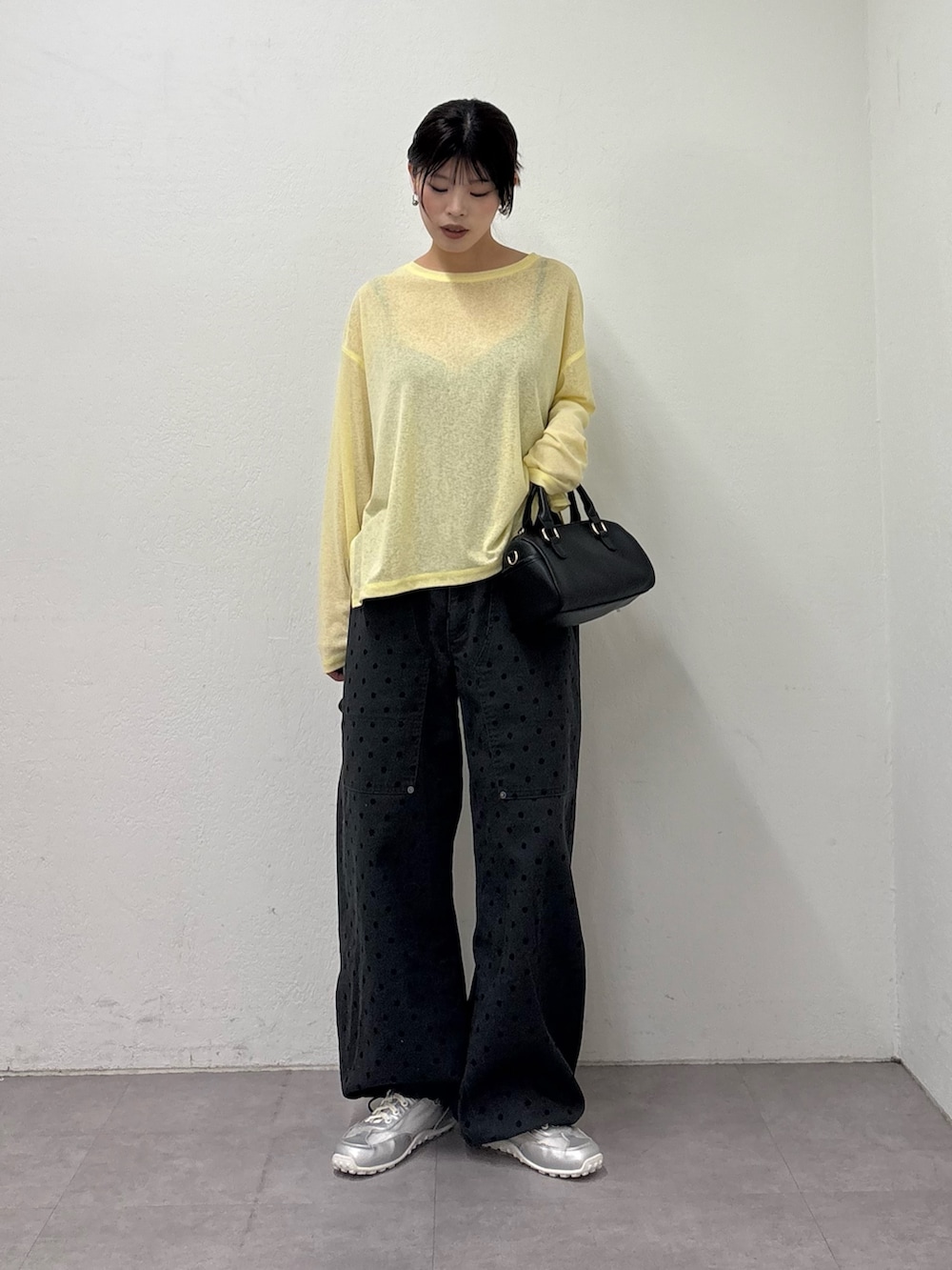 イエロー系のTシャツ/カットソー、ブラック系のショルダーバッグ、グレー系のその他パンツを着用したレディースの冬コーディネートの2枚目の写真