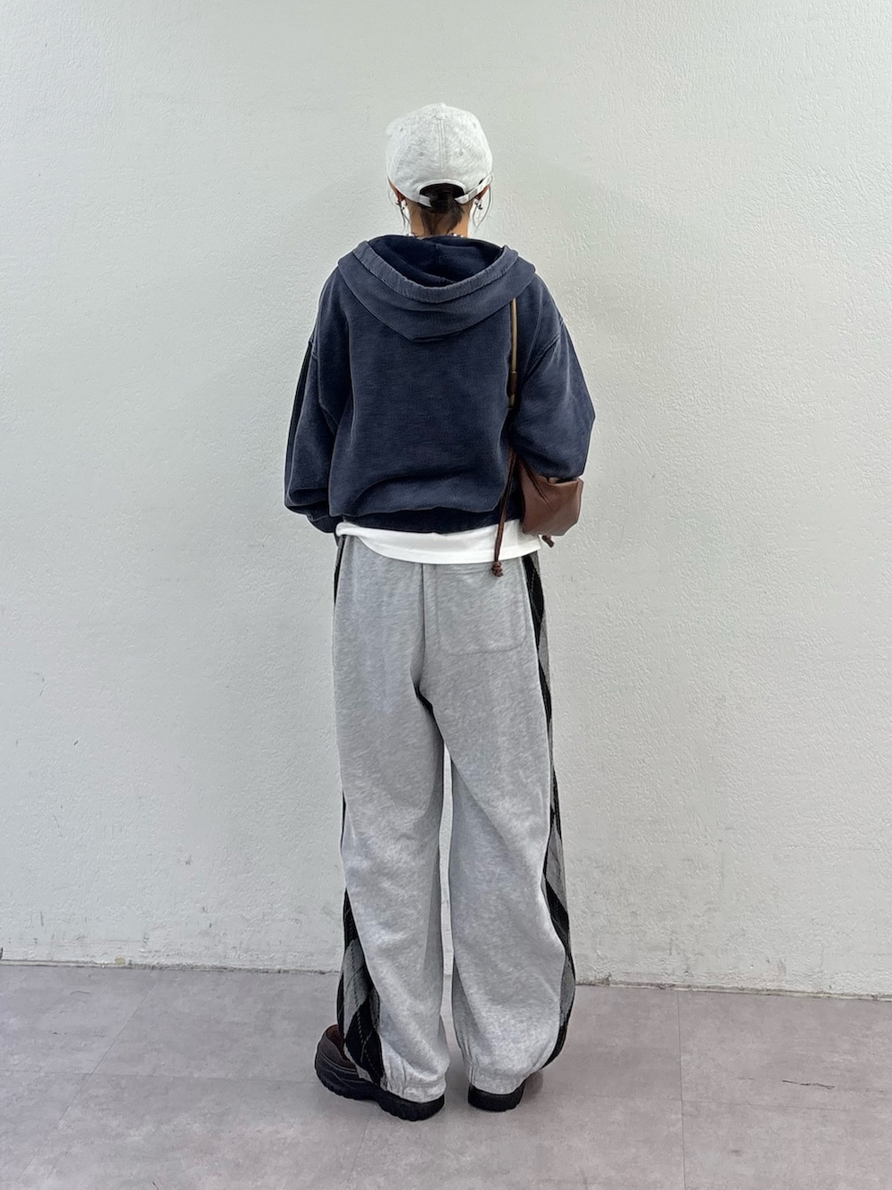 グレー系のパーカー、ホワイト系のTシャツ/カットソー、グレー系のその他パンツを着用したレディースの秋コーディネートの3枚目の写真