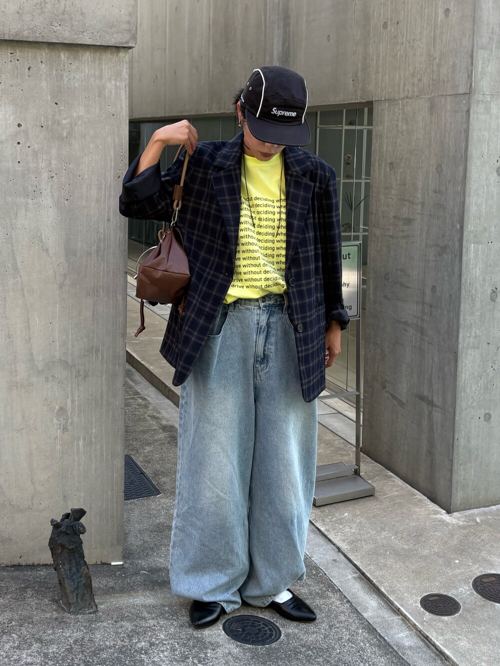 イエロー系のTシャツ/カットソー、ブルー系のテーラードジャケット、ブルー系のデニムパンツを着用したレディースの秋コーディネートの2枚目の写真