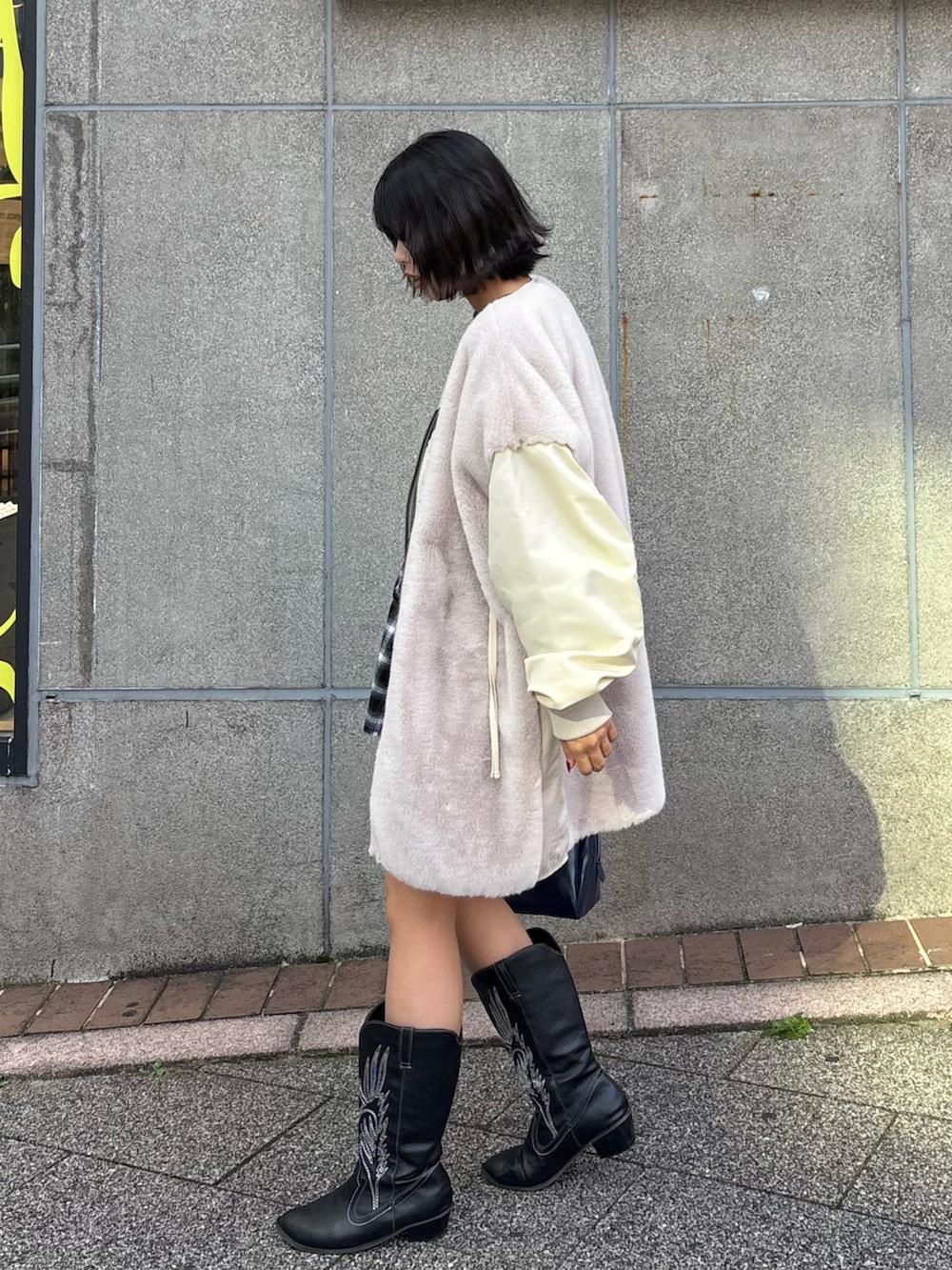 ブラウン系のTシャツ/カットソー、ホワイト系のミリタリージャケット、ブルー系のトートバッグを着用したレディースの秋コーディネートの2枚目の写真