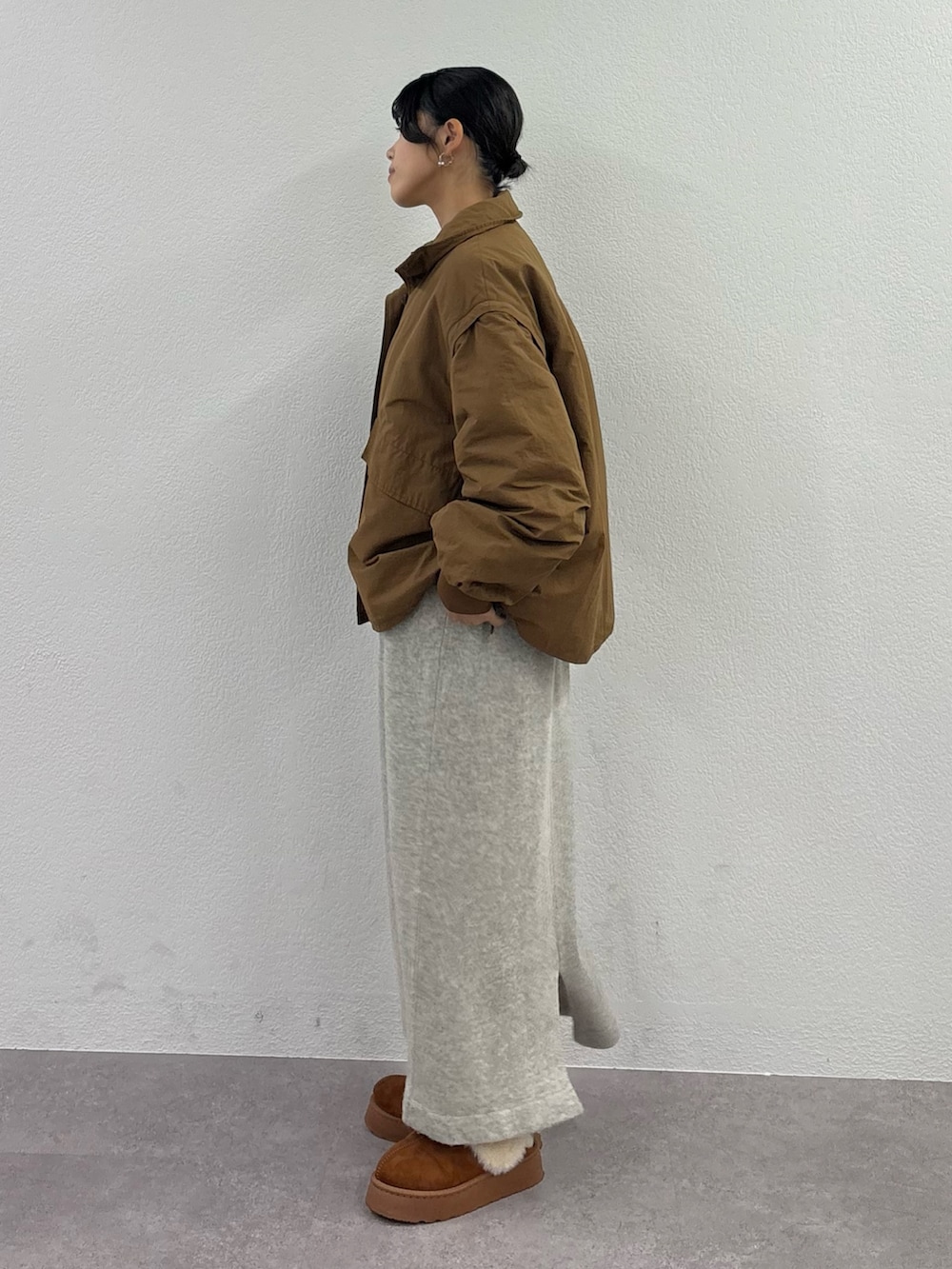 ブラウン系のブルゾン、ブラウン系のサンダル、イエロー系のハンドバッグを着用したレディースの秋コーディネートの3枚目の写真