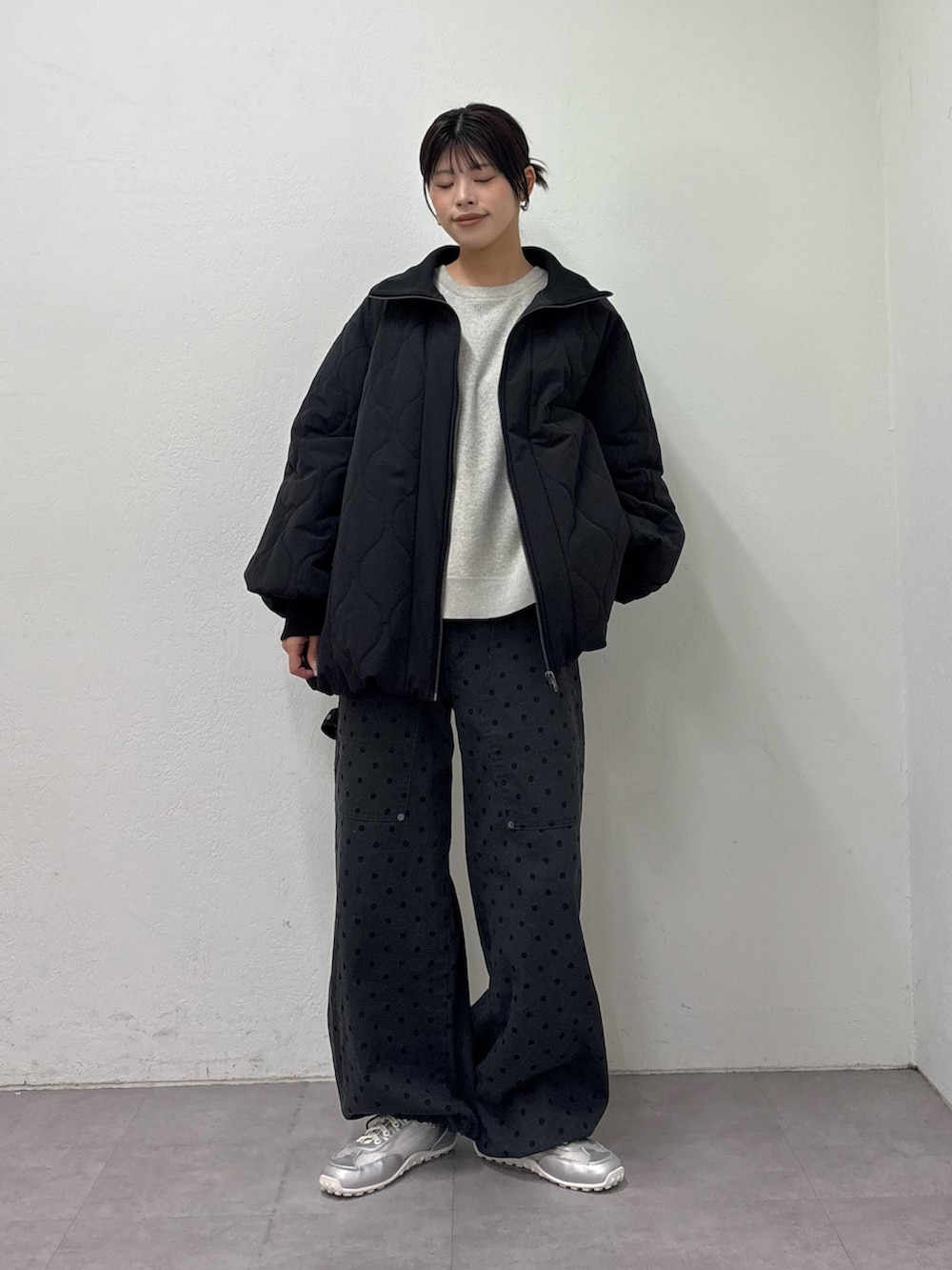 ブラック系のブルゾン、ホワイト系のニット/セーター、グレー系のその他パンツを着用したレディースの冬コーディネートの2枚目の写真