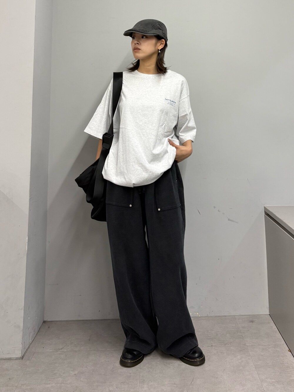 グレー系のTシャツ/カットソー、ブラック系のショルダーバッグ、ブラック系のスウェットパンツを着用したレディースの春コーディネートの3枚目の写真