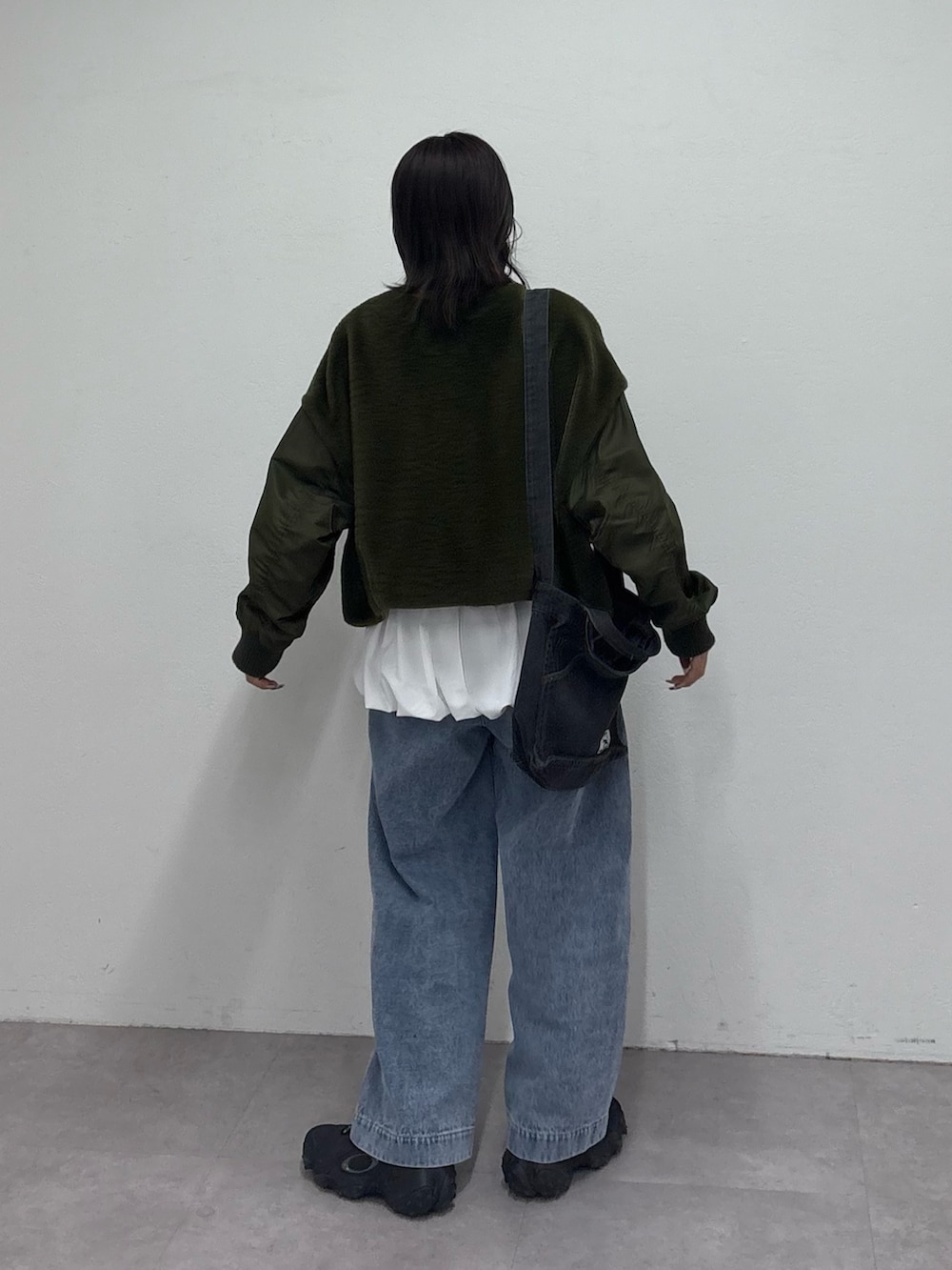 グリーン系のミリタリージャケット、ホワイト系のTシャツ/カットソー、ブルー系のデニムパンツを着用したレディースの冬コーディネートの4枚目の写真