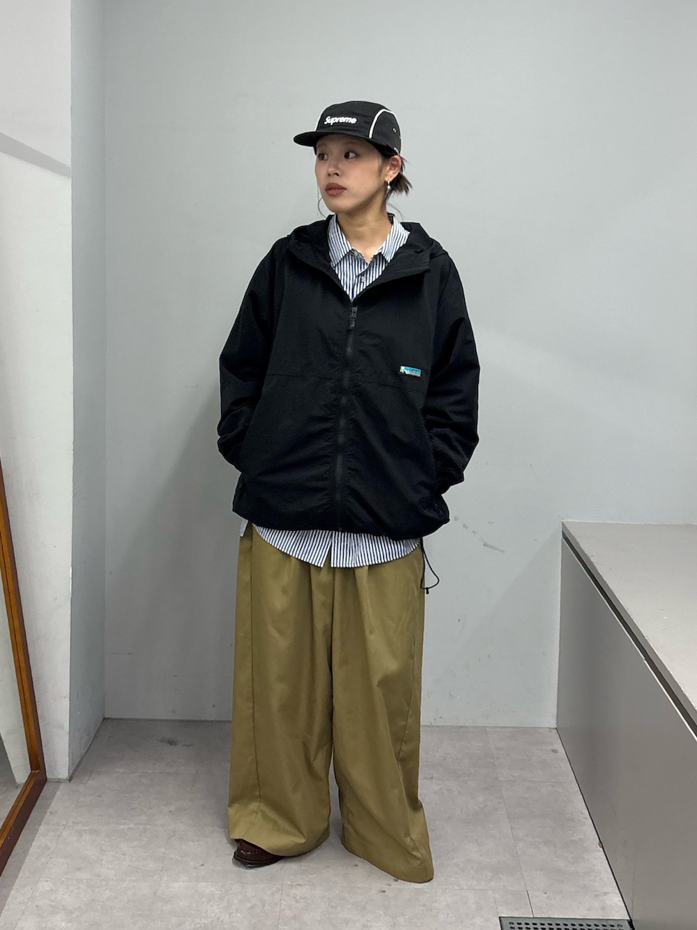 ブラック系のパーカー、ブルー系のシャツ/ブラウス、ベージュ系のデニムパンツを着用したレディースの冬コーディネートの2枚目の写真