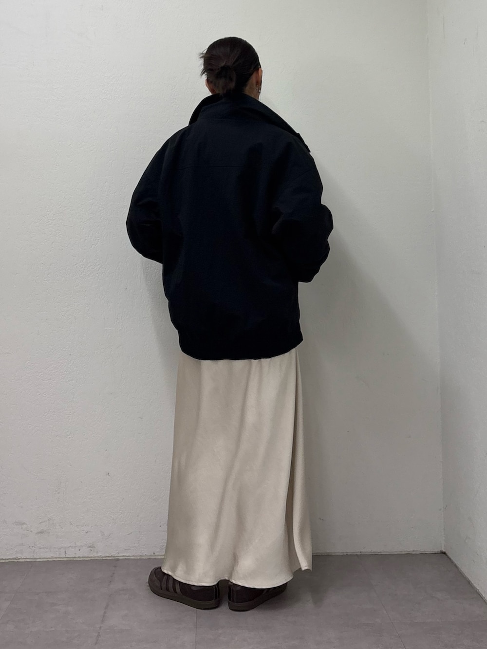 ブラック系のナイロンジャケット、グレー系のスウェット、ホワイト系のスカートを着用したレディースの冬コーディネートの3枚目の写真