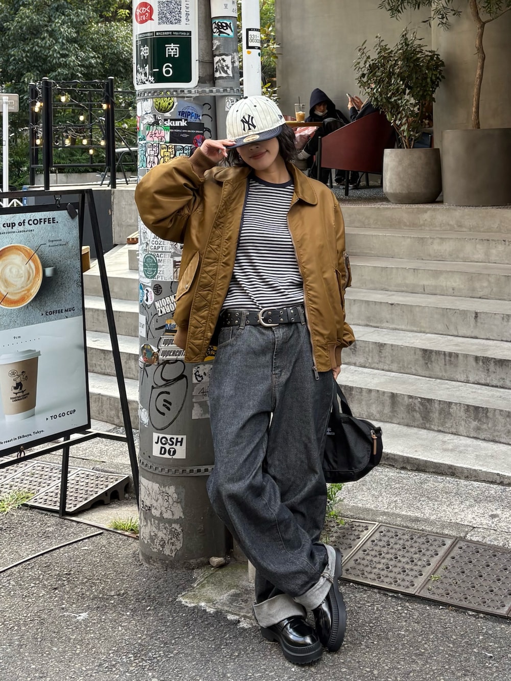 イエロー系のMA-1、ブラック系のトートバッグを着用したレディースの秋コーディネートの3枚目の写真