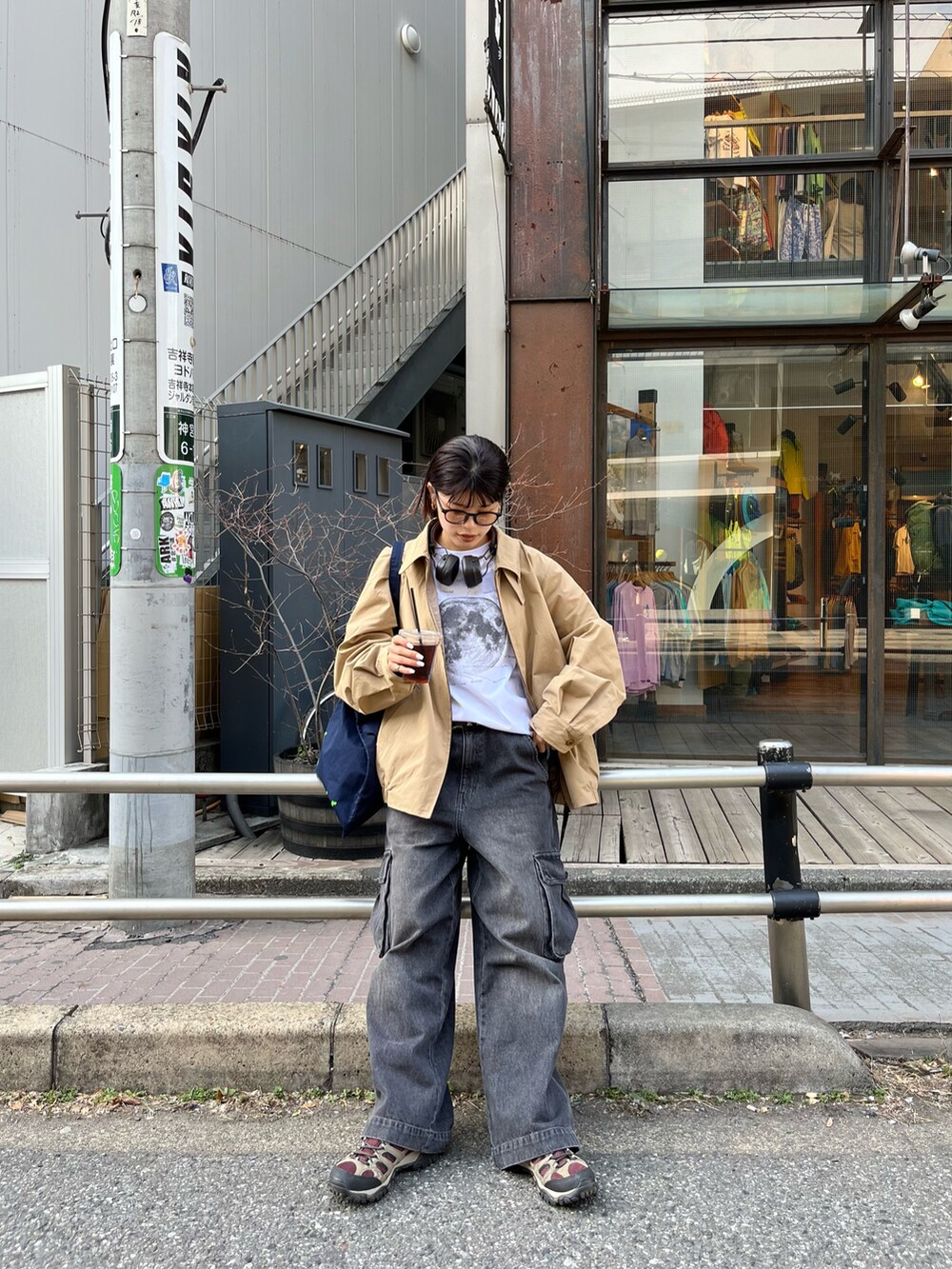 ブラック系のカーゴパンツ、ブルー系のトートバッグ、ベージュ系のブルゾンを着用したレディースの春コーディネートの3枚目の写真