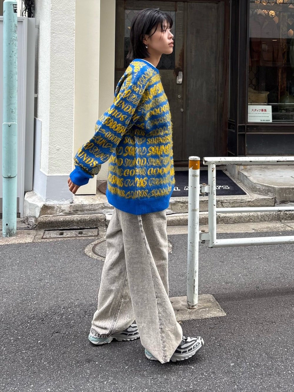 イエロー系のニット/セーター、ブラック系のデニムパンツ、ブルー系のトートバッグを着用したレディースの秋コーディネートの4枚目の写真