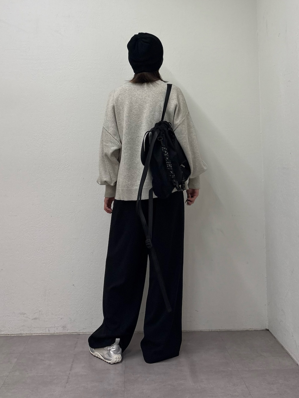 ホワイト系のニット/セーター、ブラック系のスラックス、シルバー系のスニーカーを着用したレディースの冬コーディネートの3枚目の写真