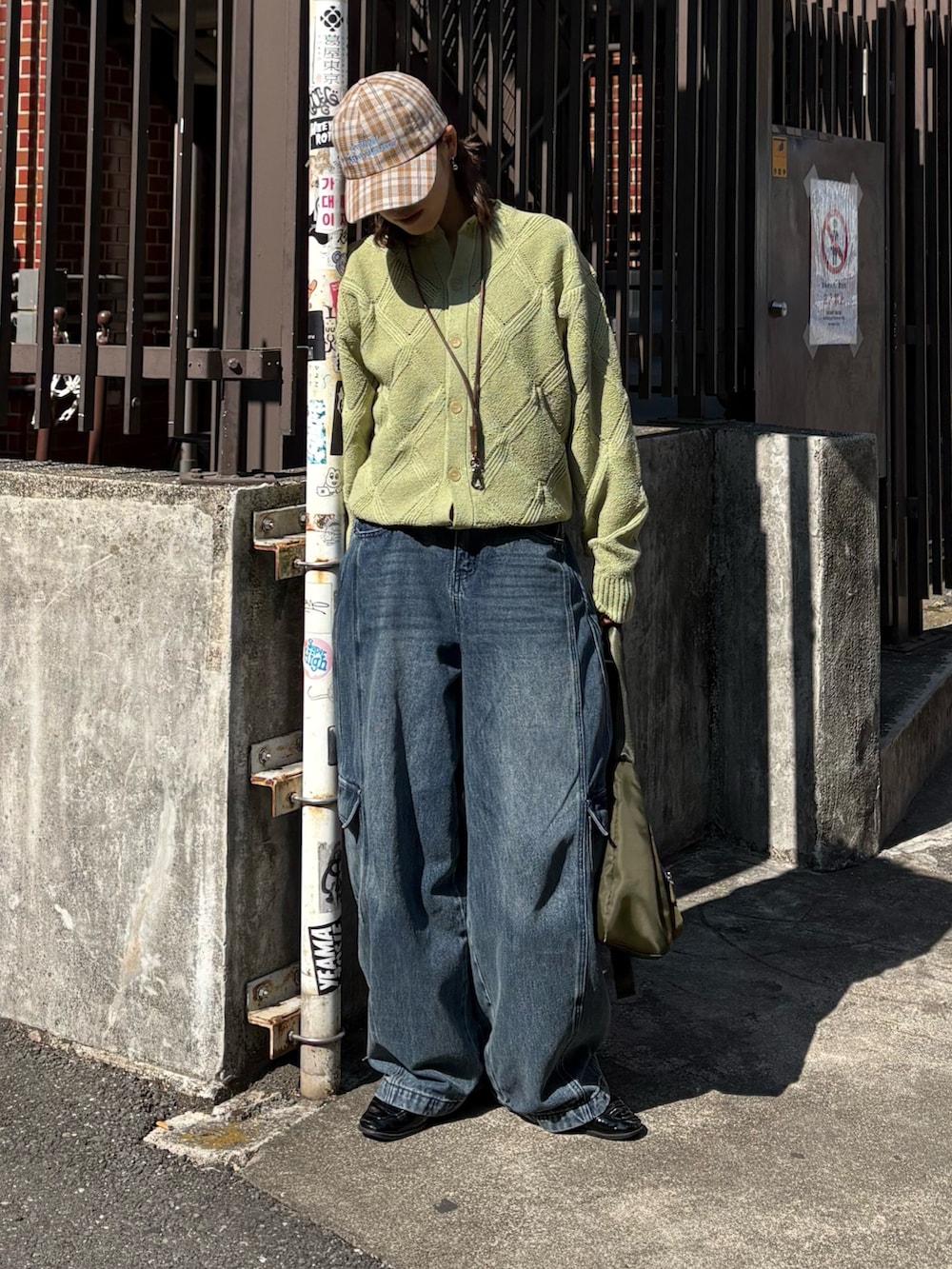 グリーン系のカーディガン/ボレロ、ブルー系のカーゴパンツ、ベージュ系のハットを着用したレディースの春コーディネートの2枚目の写真