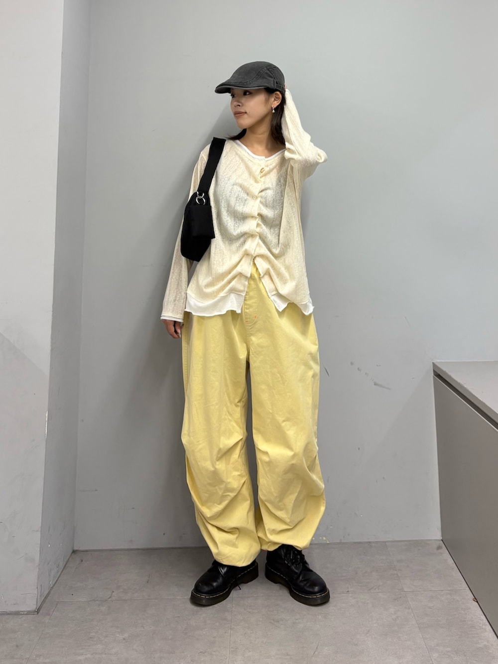 イエロー系のTシャツ/カットソー、イエロー系のその他パンツ、ブラック系のショルダーバッグを着用したレディースの春コーディネートの2枚目の写真