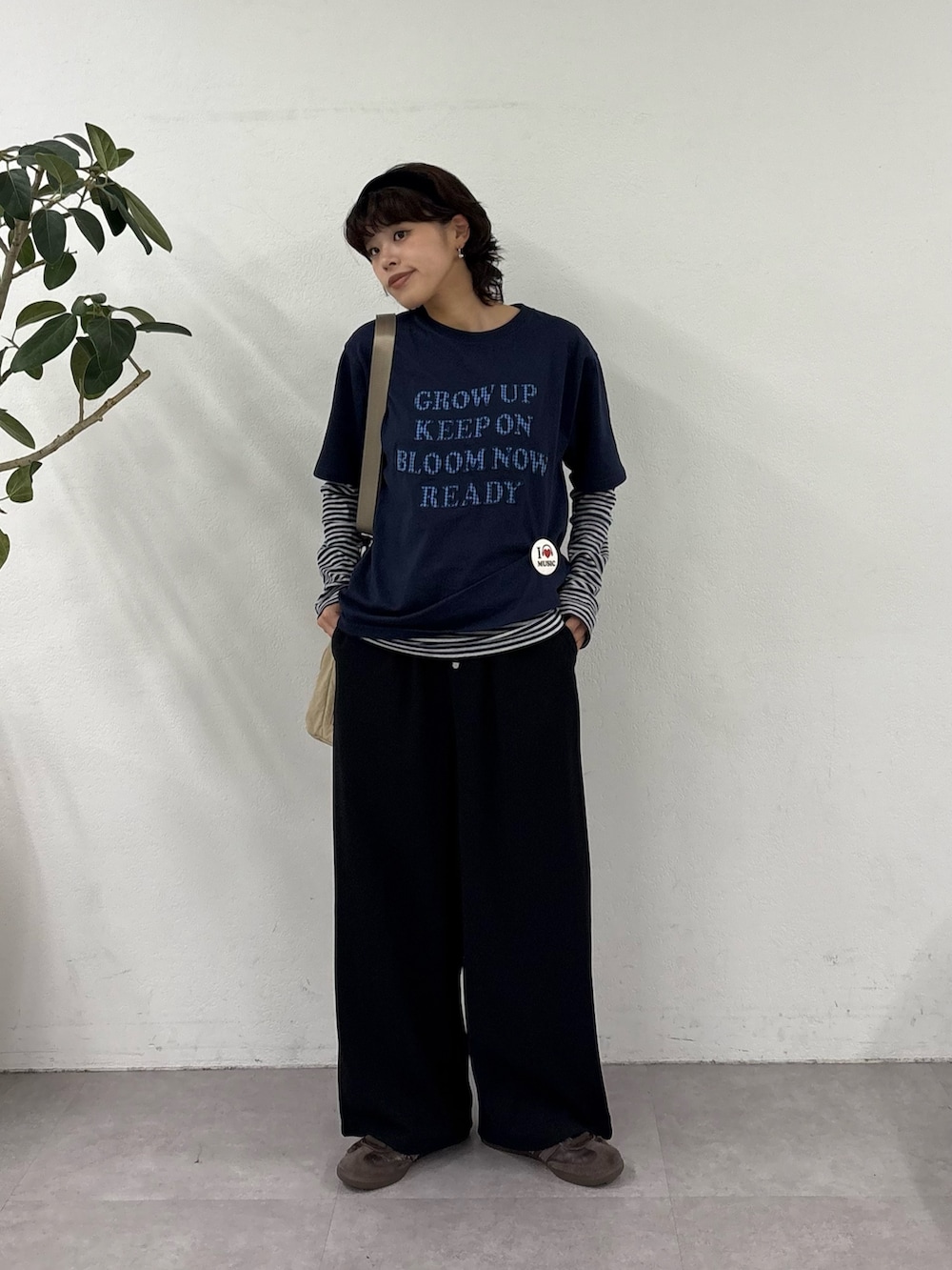 ブルー系のTシャツ/カットソー、ブラック系のスラックス、ベージュ系のトートバッグを着用したレディースの春コーディネートの2枚目の写真