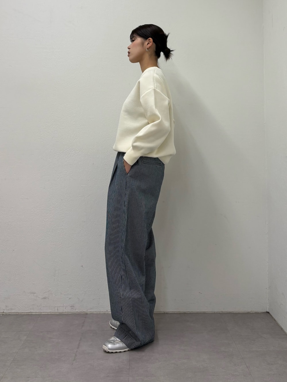 ホワイト系のニット/セーター、ブルー系のデニムパンツ、シルバー系のスニーカーを着用したレディースの冬コーディネートの2枚目の写真