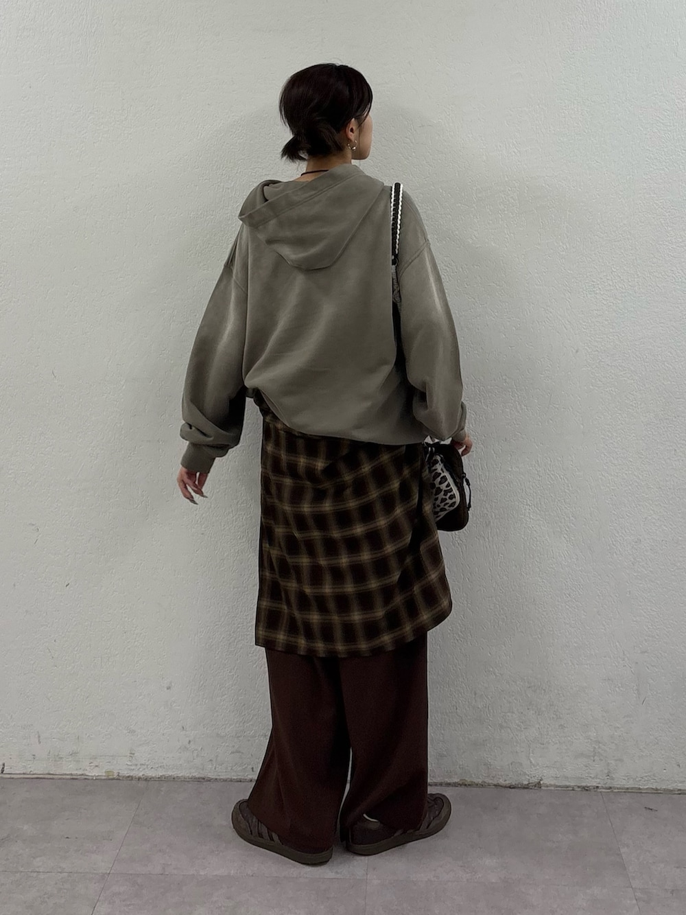 ベージュ系のパーカー、ブラウン系のシャツ/ブラウス、ブラウン系のスラックスを着用したレディースの冬コーディネートの3枚目の写真