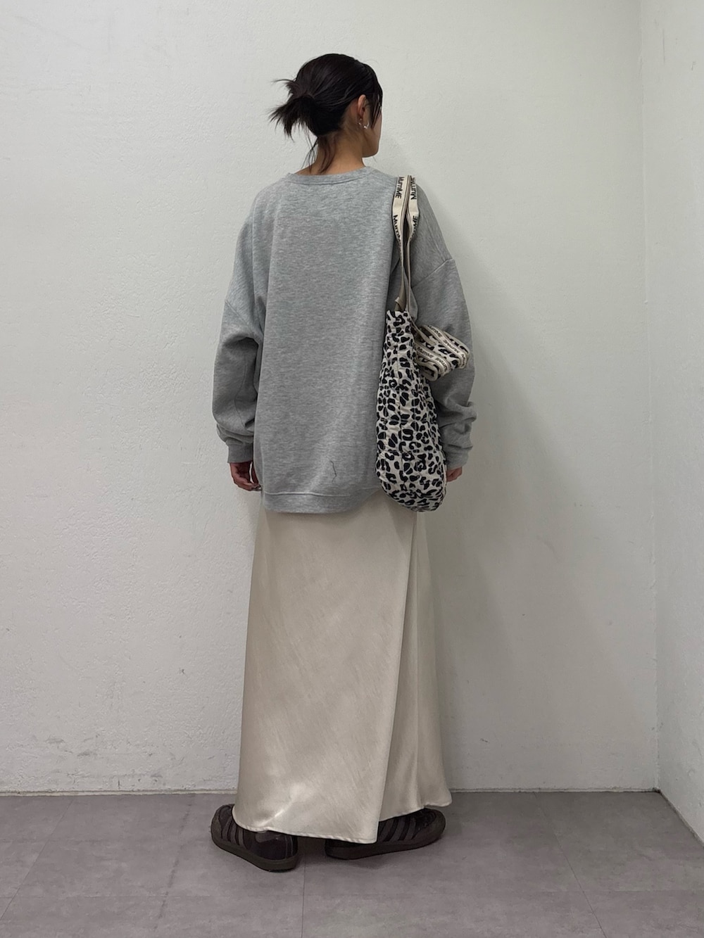 グレー系のスウェット、ホワイト系のスカート、ホワイト系のトートバッグを着用したレディースの冬コーディネートの3枚目の写真