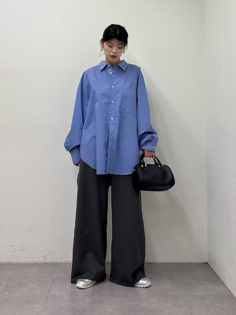 ブルー系のシャツ/ブラウス、ブラック系のショルダーバッグ、グレー系のスウェットパンツを着用したレディースの冬コーディネートの2枚目の写真