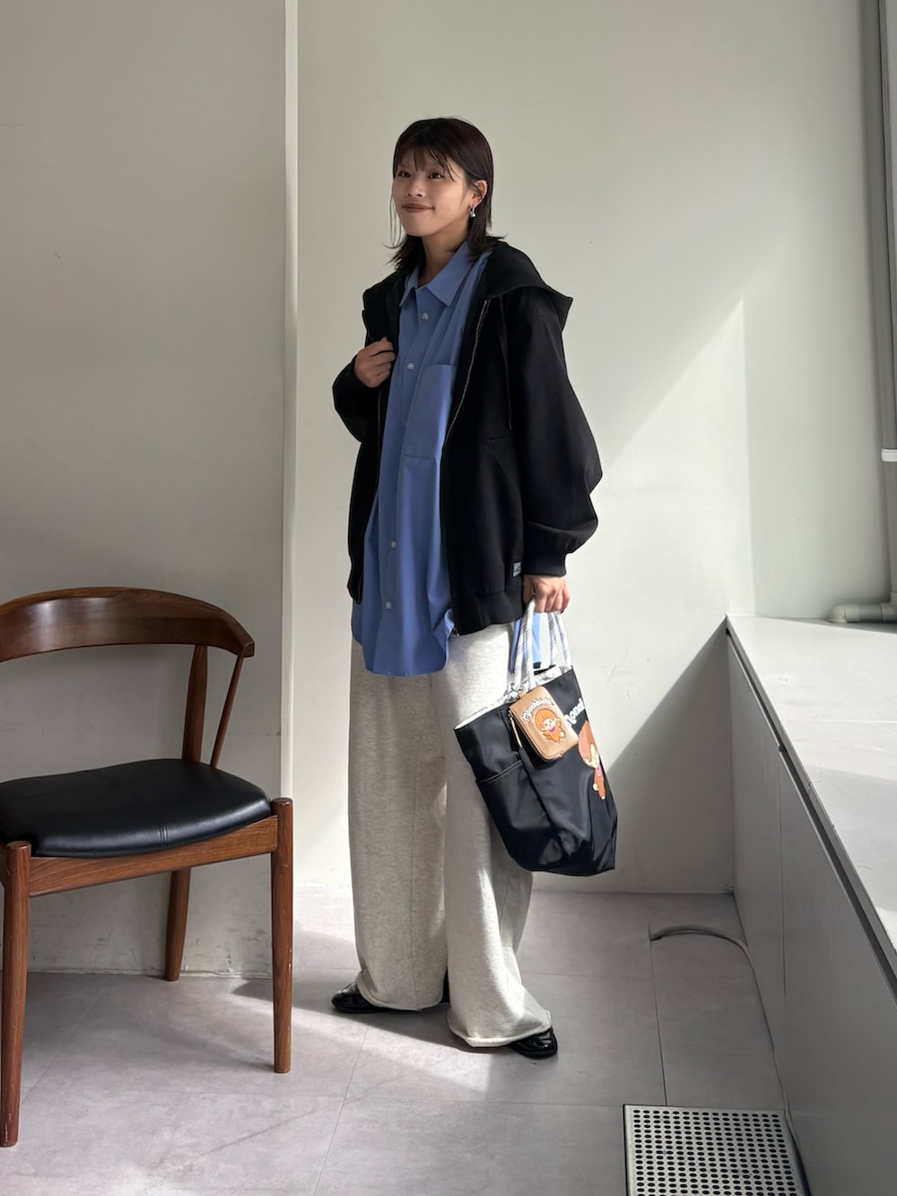 ブルー系のシャツ/ブラウス、ブラック系のデニムジャケット、ブラック系のショルダーバッグを着用したレディースの春コーディネートの2枚目の写真