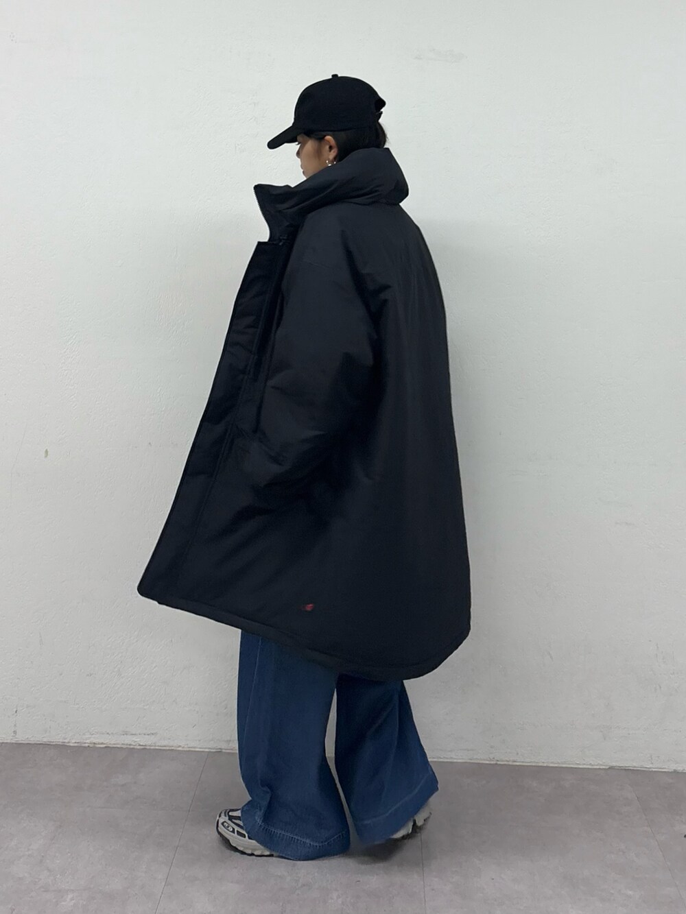 ブルー系のデニムパンツ、ブラック系のダウンジャケット/コート、ブラック系のスウェットを着用したレディースの秋コーディネートの3枚目の写真