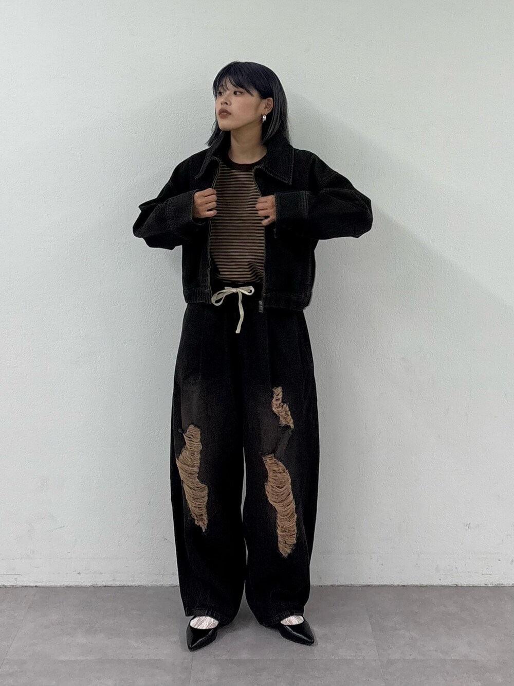 ブラック系のデニムパンツ、ブラック系のデニムジャケット、ブラウン系のTシャツ/カットソーを着用したレディースの春コーディネートの3枚目の写真