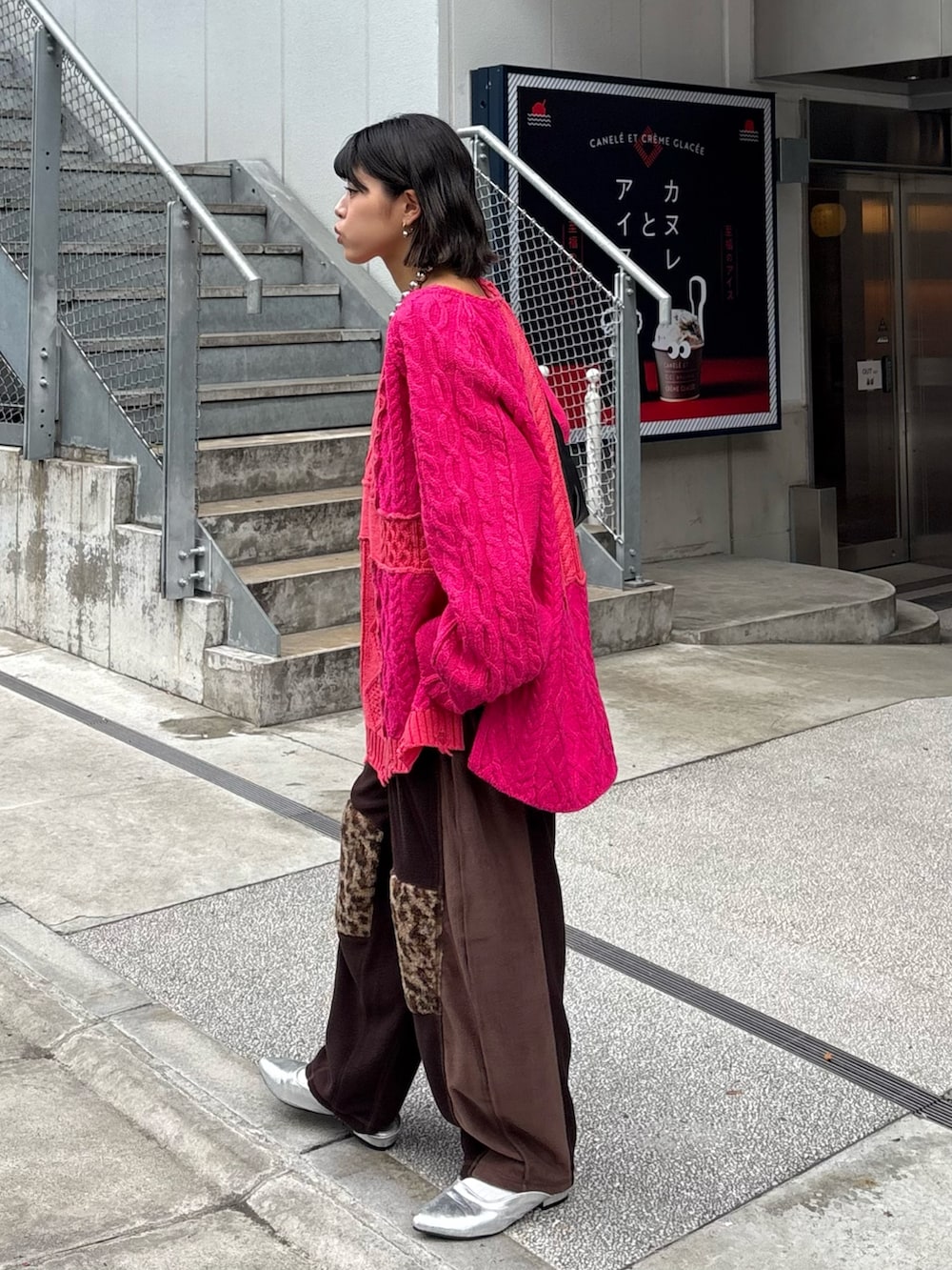 ピンク系のニット/セーター、ブラウン系のその他パンツ、ブラック系のショルダーバッグを着用したレディースの秋コーディネートの2枚目の写真