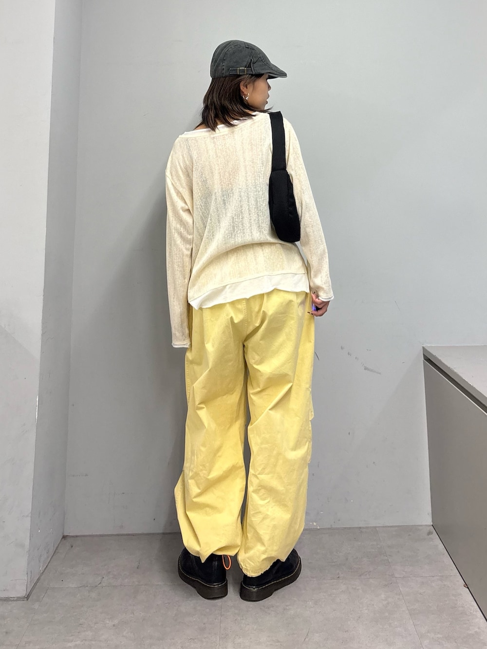 イエロー系のTシャツ/カットソー、イエロー系のその他パンツ、ブラック系のショルダーバッグを着用したレディースの春コーディネートの4枚目の写真