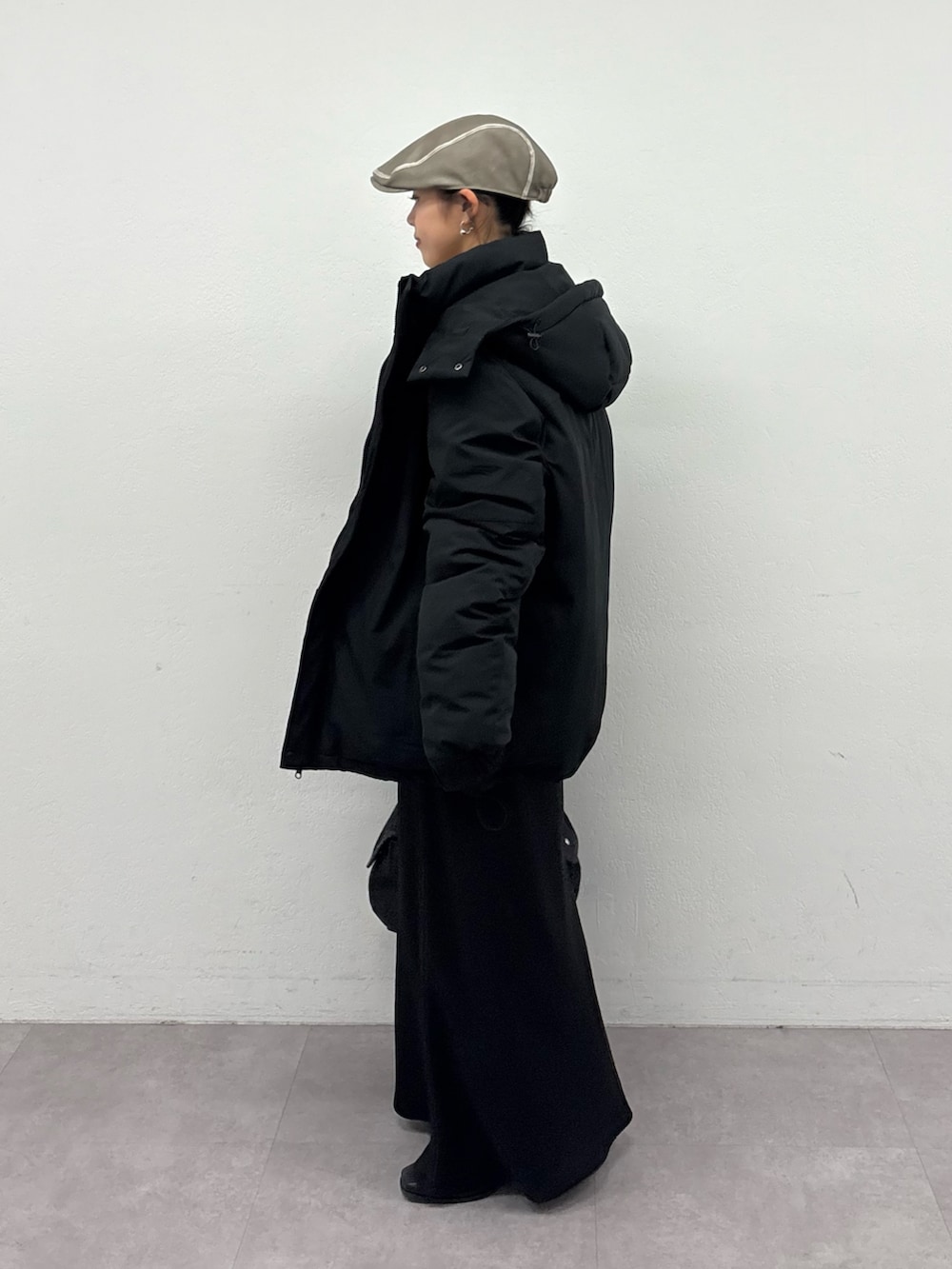 ブラック系のスカート、ブラック系のブーツ、グレー系のスウェットを着用したレディースの冬コーディネートの2枚目の写真