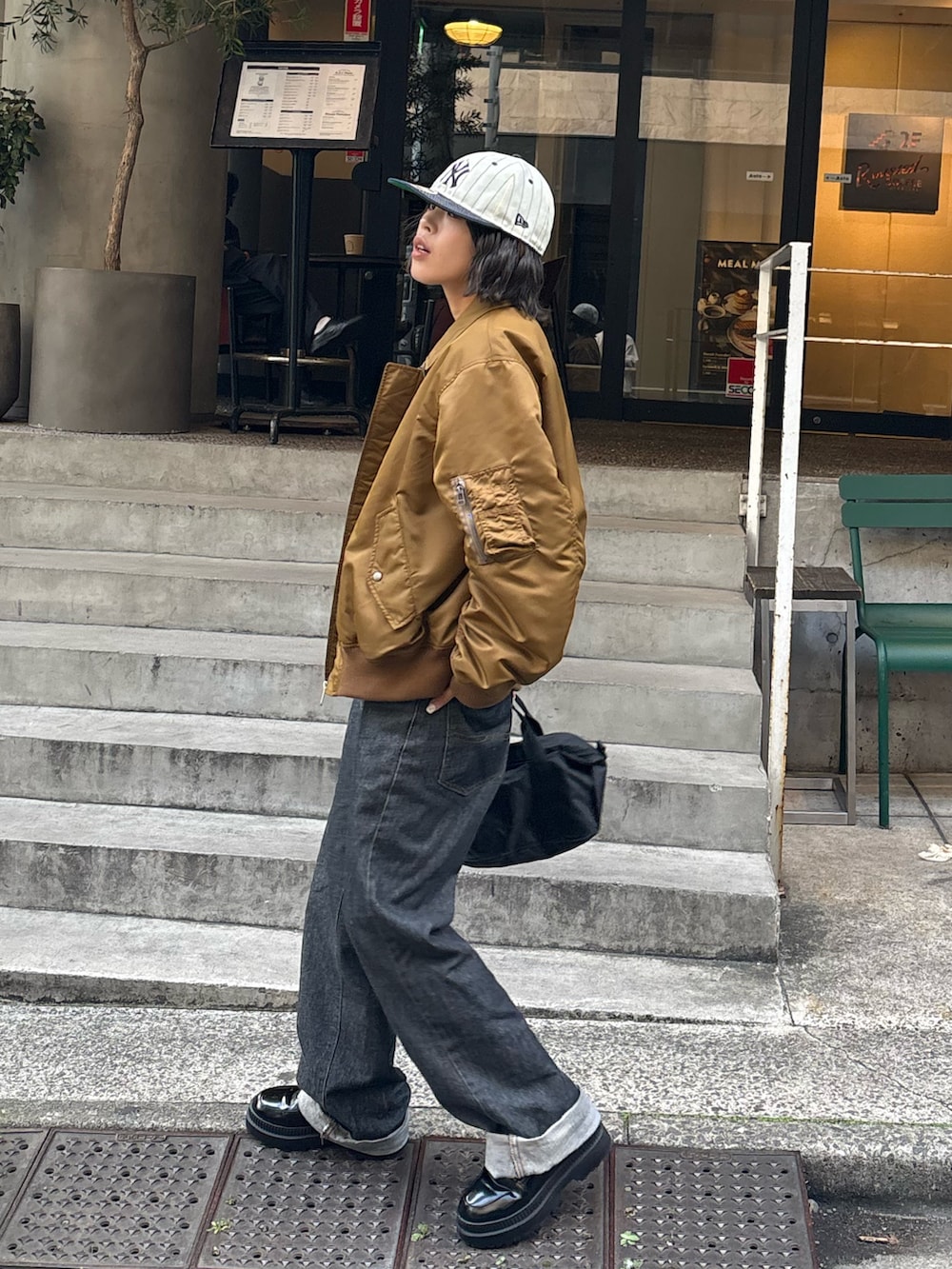 イエロー系のMA-1、ブラック系のトートバッグを着用したレディースの秋コーディネートの6枚目の写真