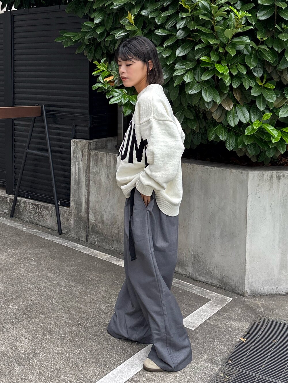 ホワイト系のニット/セーター、グレー系のスラックスを着用したレディースの秋コーディネートの2枚目の写真