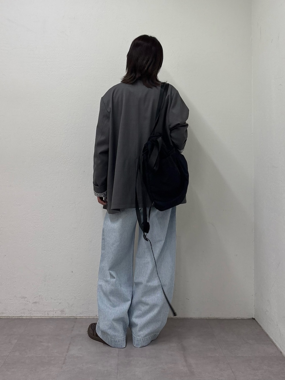 グレー系のテーラードジャケット、ホワイト系のTシャツ/カットソー、ブルー系のデニムパンツを着用したレディースの冬コーディネートの3枚目の写真