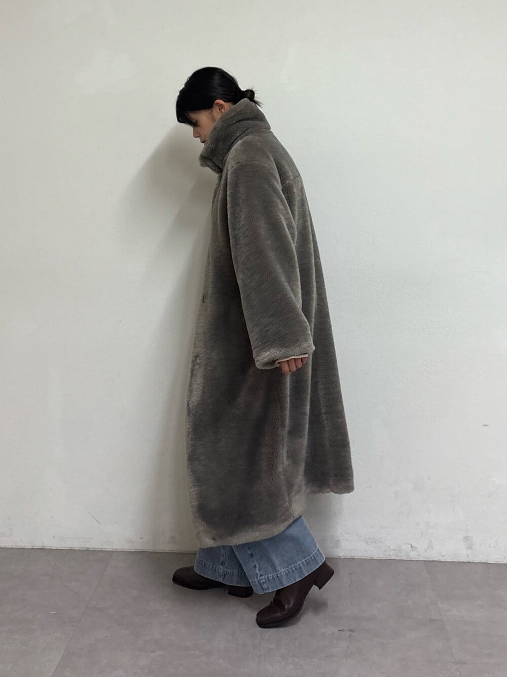 グレー系のその他アウター、ブルー系のデニムパンツ、ブラウン系のブーツを着用したレディースの秋コーディネートの2枚目の写真