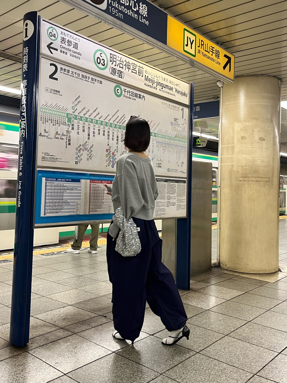 ブラック系のサンダル、ブルー系のパンツ、シルバー系のハンドバッグを着用したレディースの春コーディネートの2枚目の写真