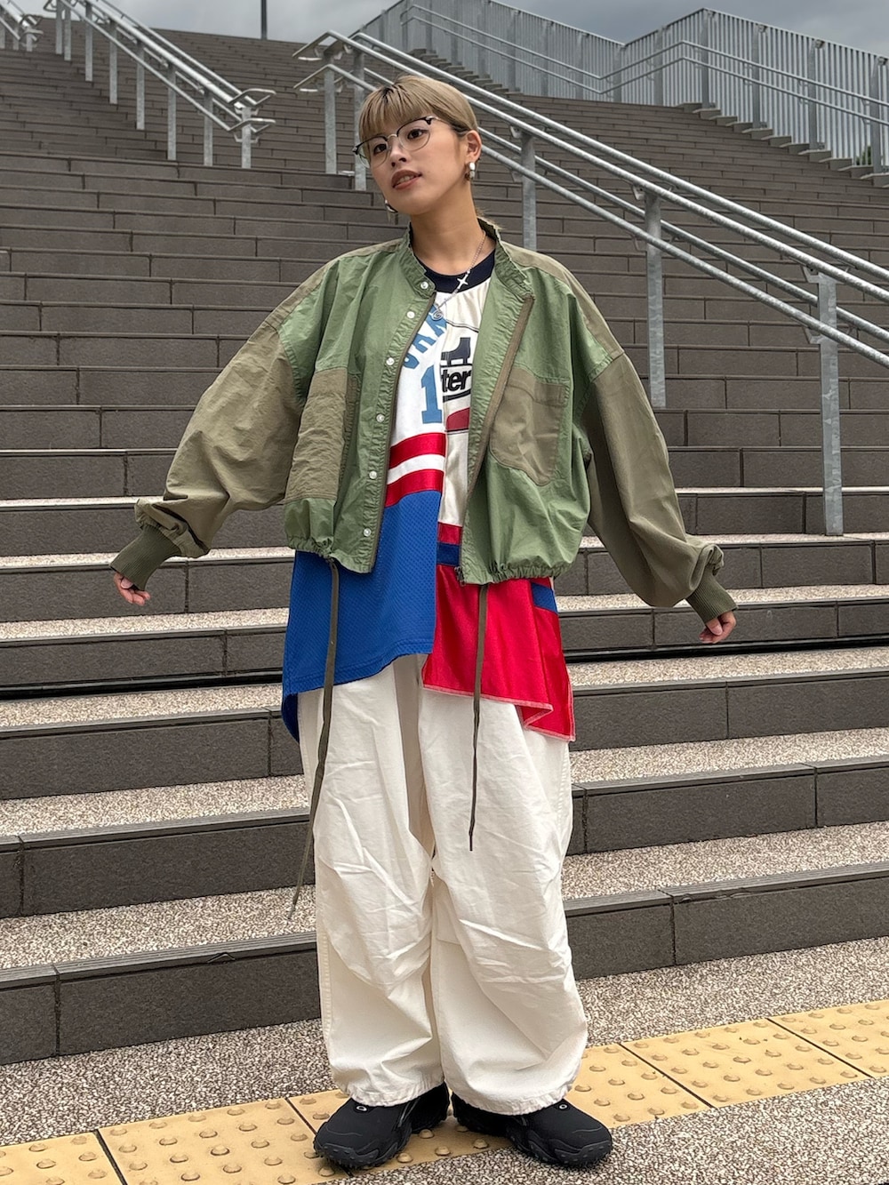 ホワイト系のTシャツ/カットソー、グリーン系のブルゾン、ホワイト系のカーゴパンツを着用したレディースの秋コーディネートの2枚目の写真