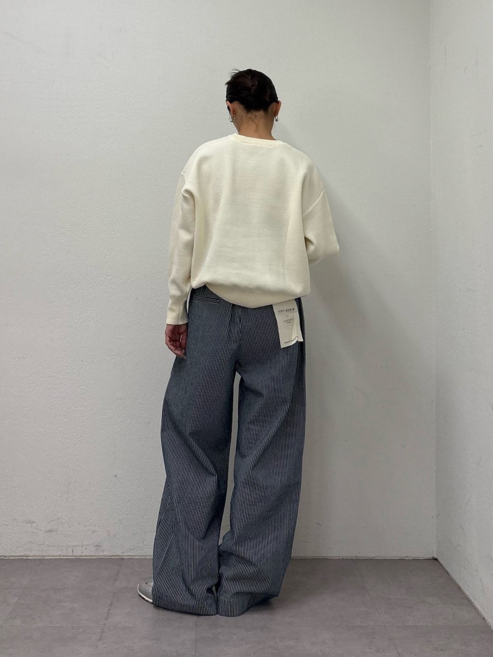 ホワイト系のニット/セーター、ブルー系のデニムパンツ、シルバー系のスニーカーを着用したレディースの冬コーディネートの3枚目の写真