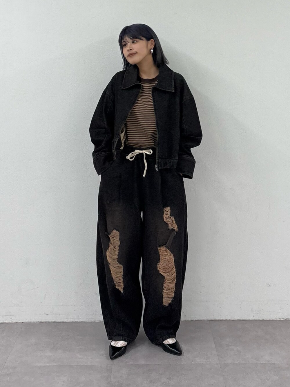 ブラック系のデニムパンツ、ブラック系のデニムジャケット、ブラウン系のTシャツ/カットソーを着用したレディースの春コーディネートの2枚目の写真