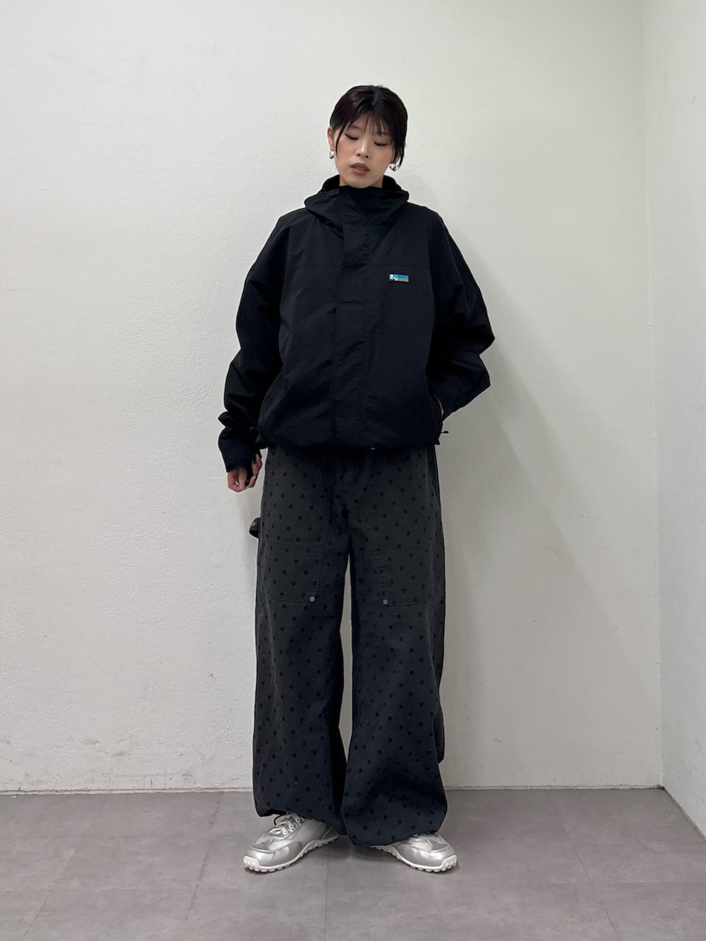 ブラック系のナイロンジャケット、グレー系のその他パンツ、シルバー系のスニーカーを着用したレディースの冬コーディネートの2枚目の写真