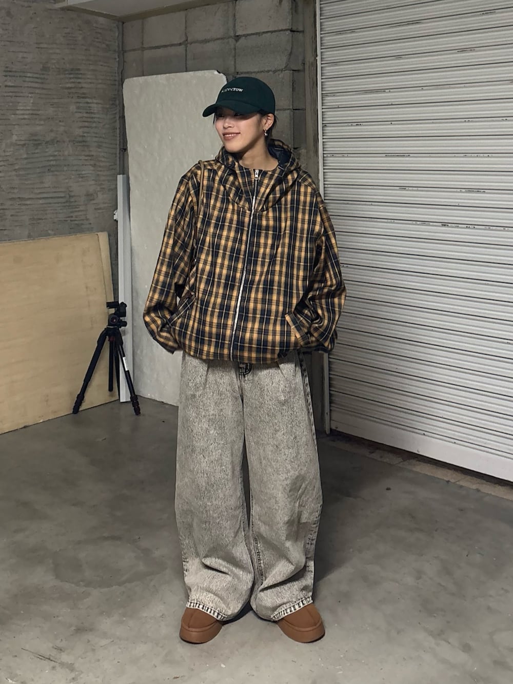 ブラック系のデニムパンツ、ブラウン系のサンダル、イエロー系のブルゾンを着用したレディースの冬コーディネートの2枚目の写真