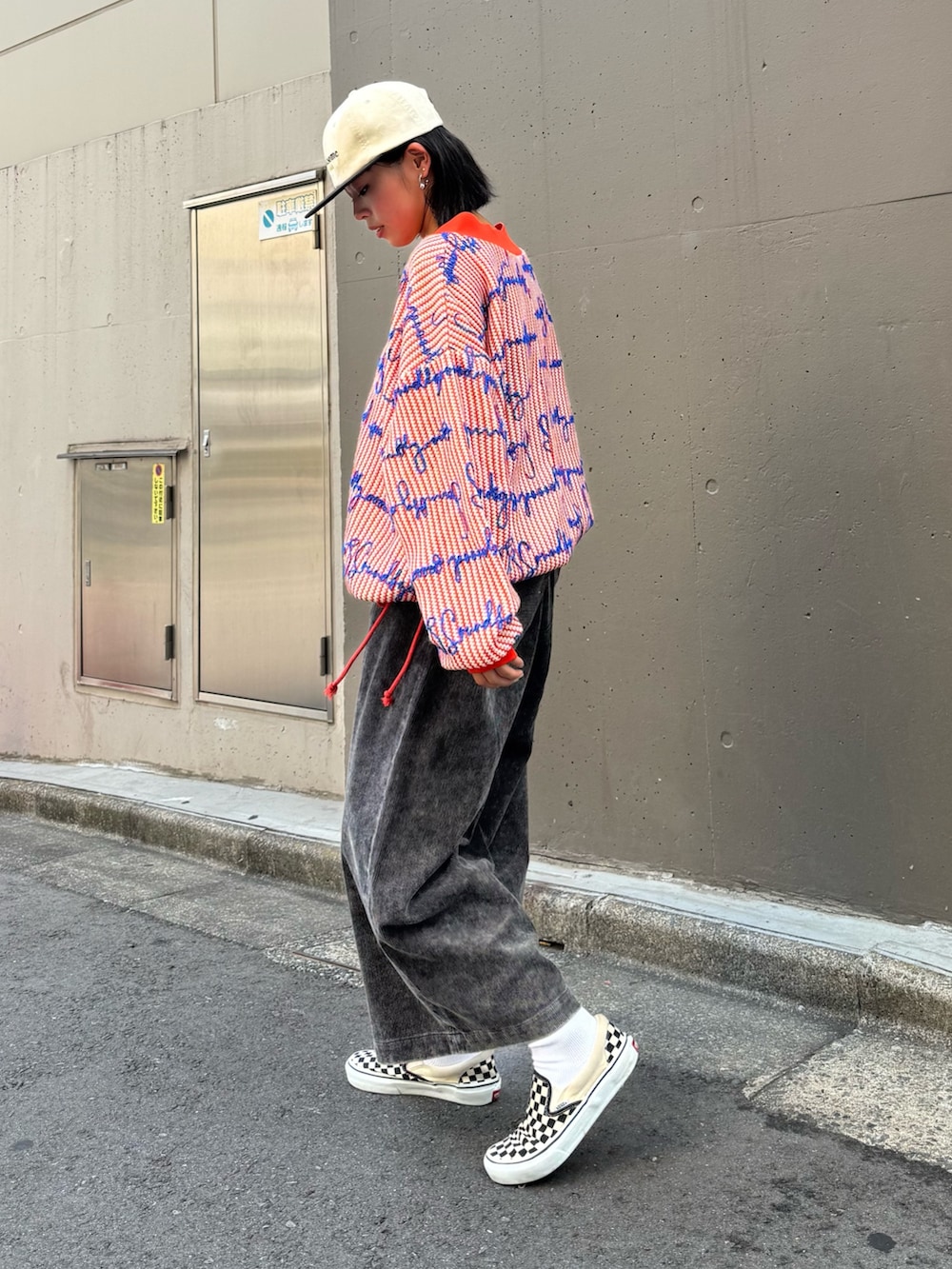 オレンジ系のニット/セーター、ブラック系のその他パンツ、ベージュ系のハットを着用したレディースの秋コーディネートの2枚目の写真