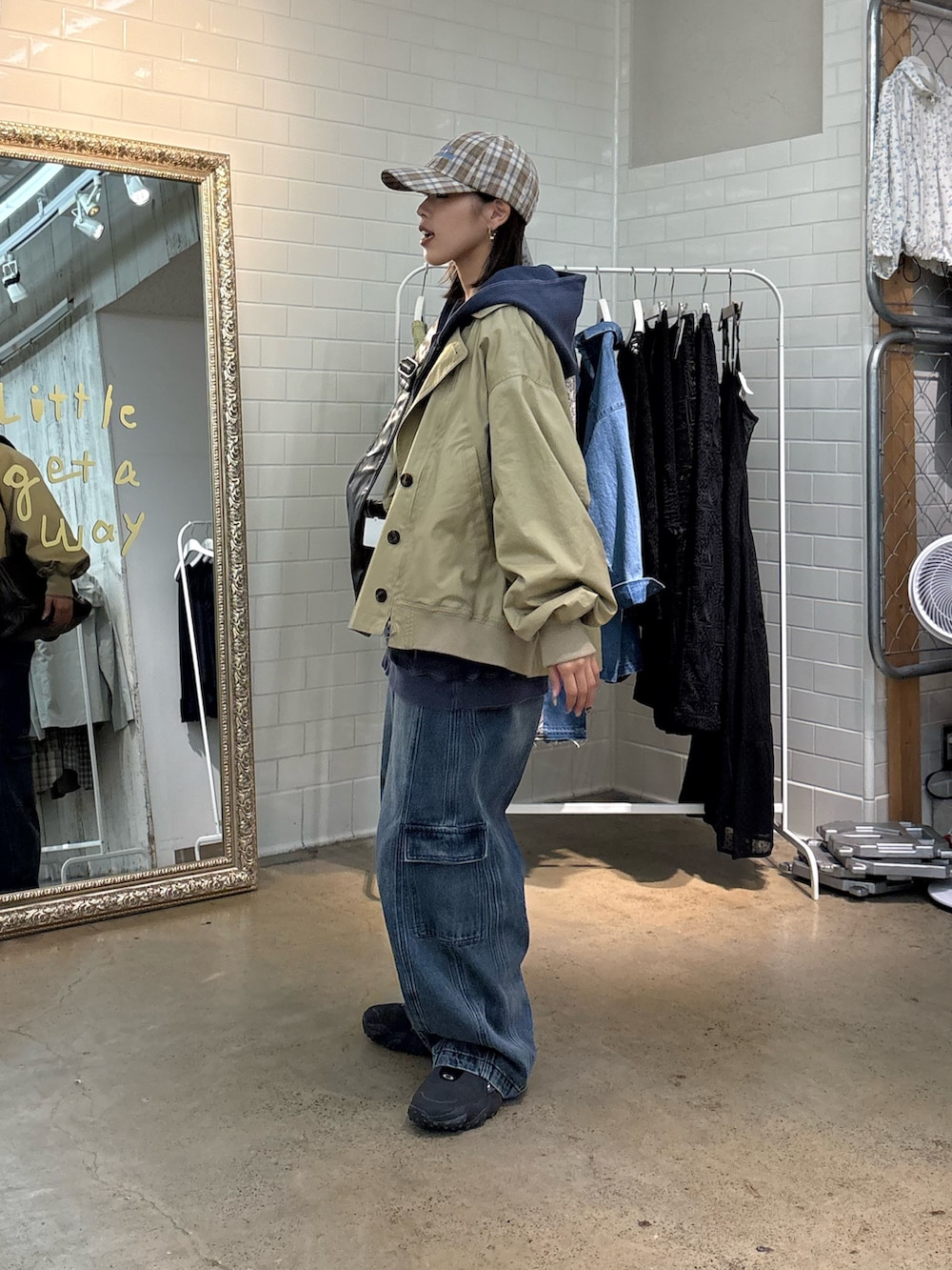 ベージュ系のトレンチコート、ブルー系のカーゴパンツ、ベージュ系のハットを着用したレディースの春コーディネートの2枚目の写真
